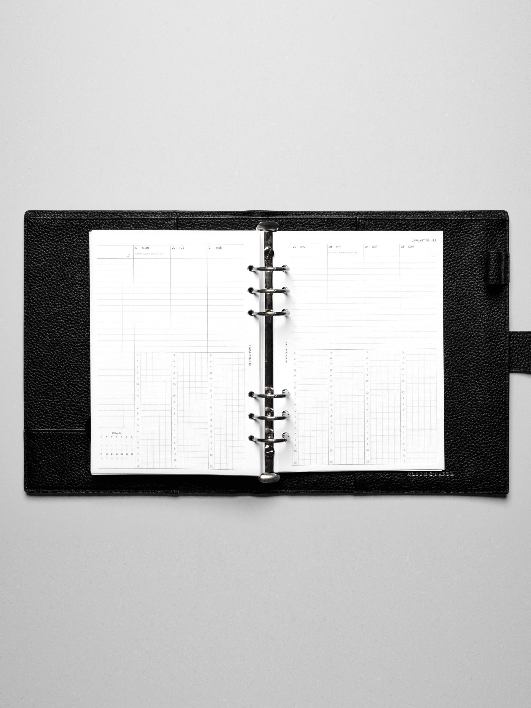Image shows the Monday Start 2026 Dated Weekly Schedule Planner Inserts in a black leather ring-bound planner.