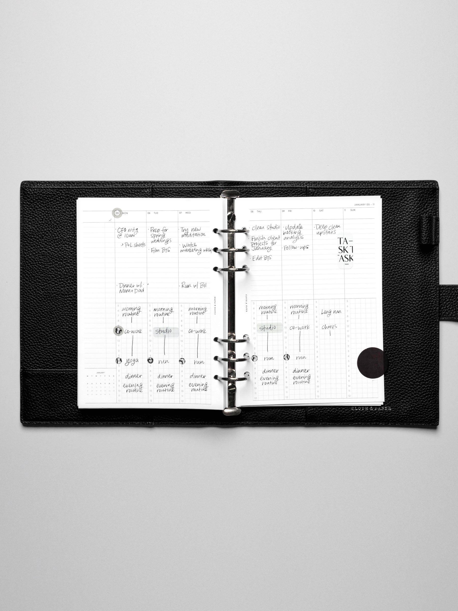 Image shows the Monday Start 2026 Dated Weekly Schedule Planner Inserts in a black leather ring-bound planner.