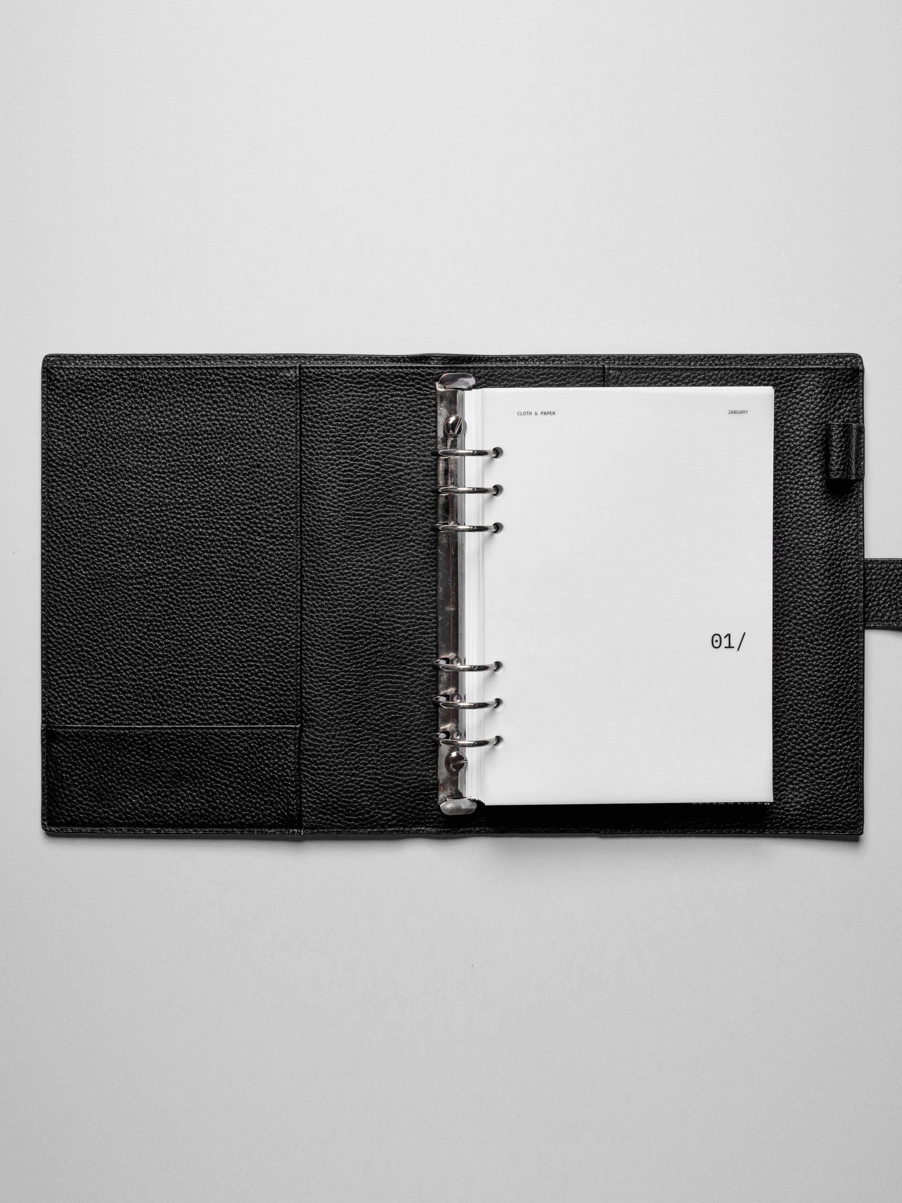 Image shows the January dashboard used in a black leather A5 ring-bound planner.