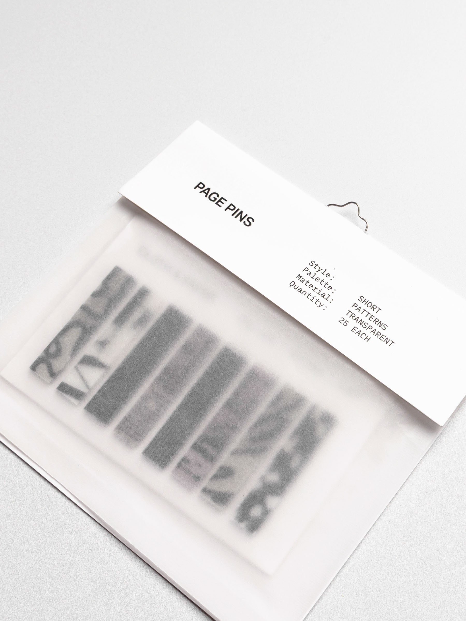 Short page pins displayed in their packaging on a neutral background.