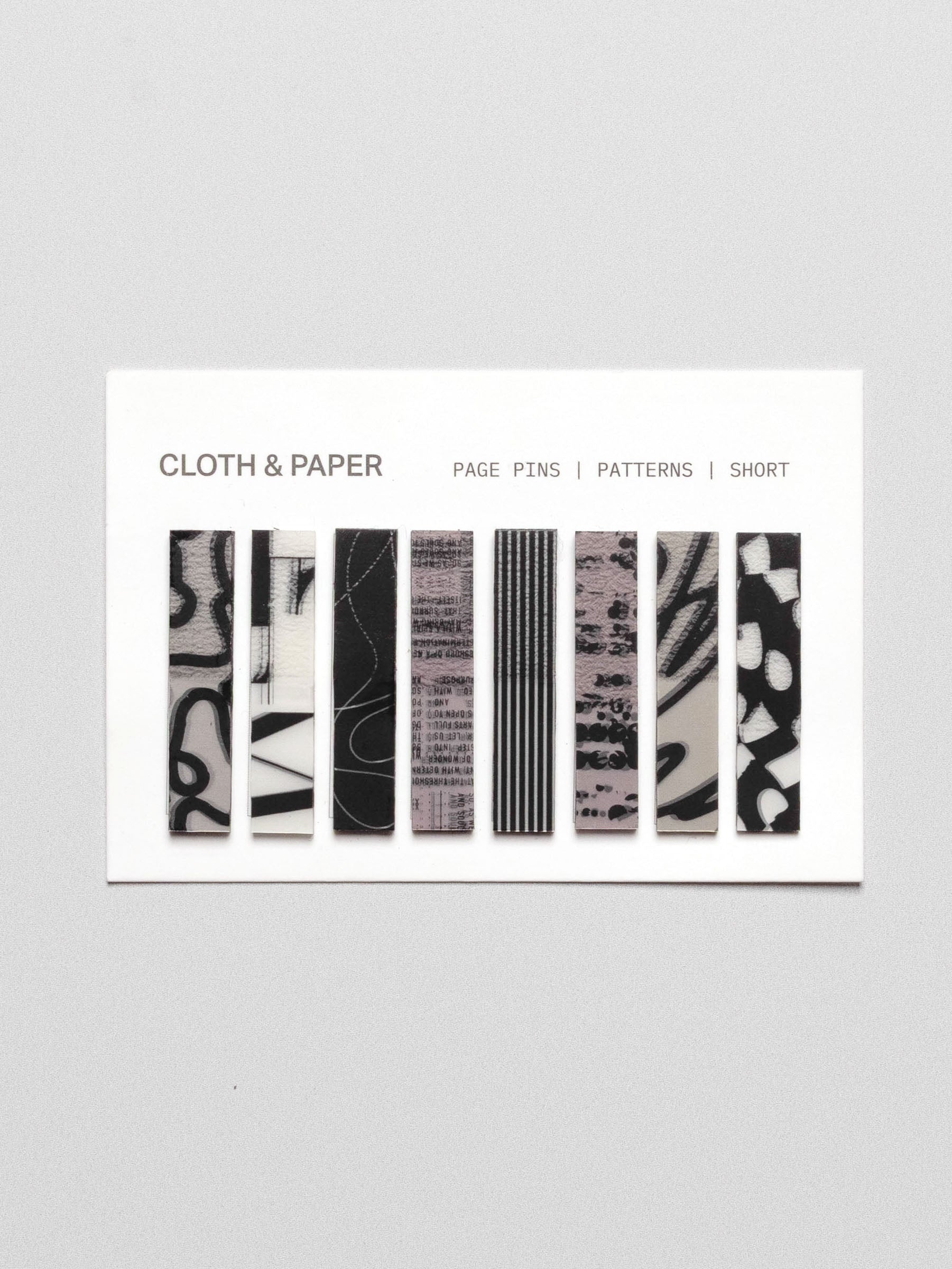 Short page pins displayed in their packaging on a neutral background.