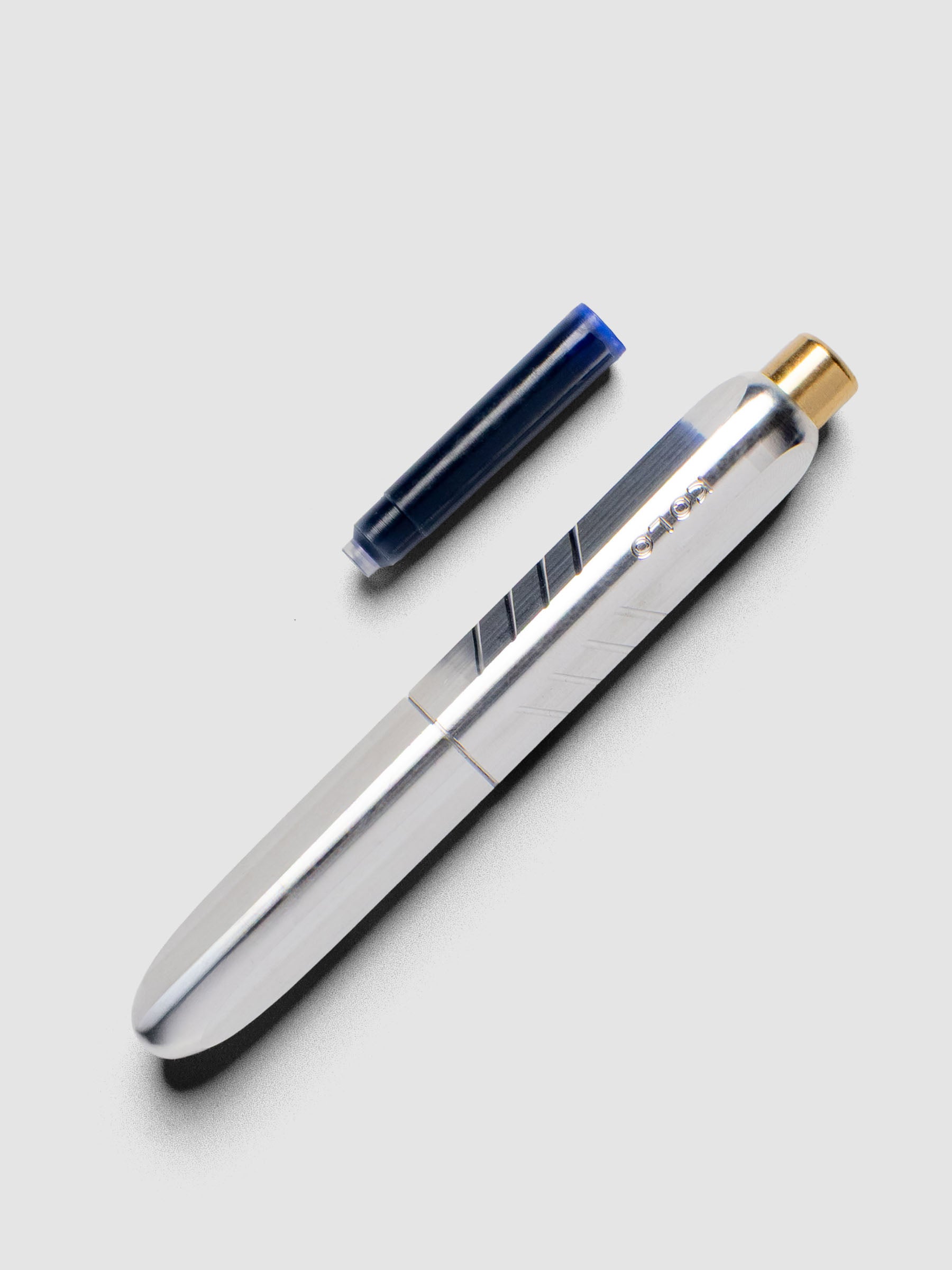 Kolo Tino Fountain Pen in the color Raw Aluminum, shown cap on with ink cartridge resting beside pen.