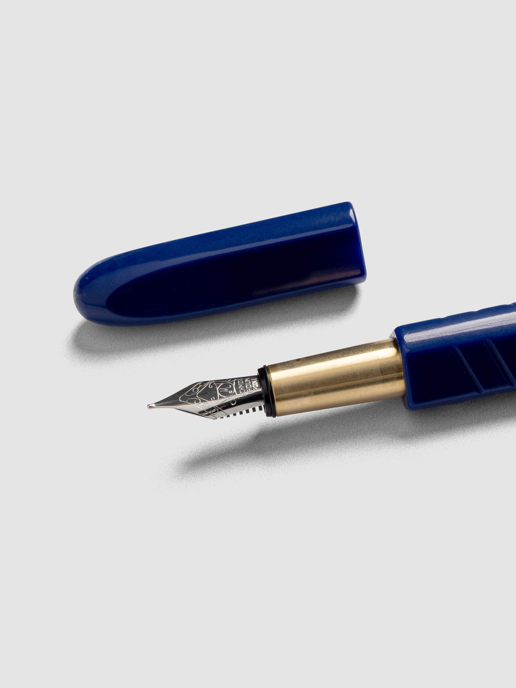 Kolo Tino Fountain Pen in the color Acrylic Albert Blue, a cobalt barrel with brass accents and a silver medium nib shown with cap off.