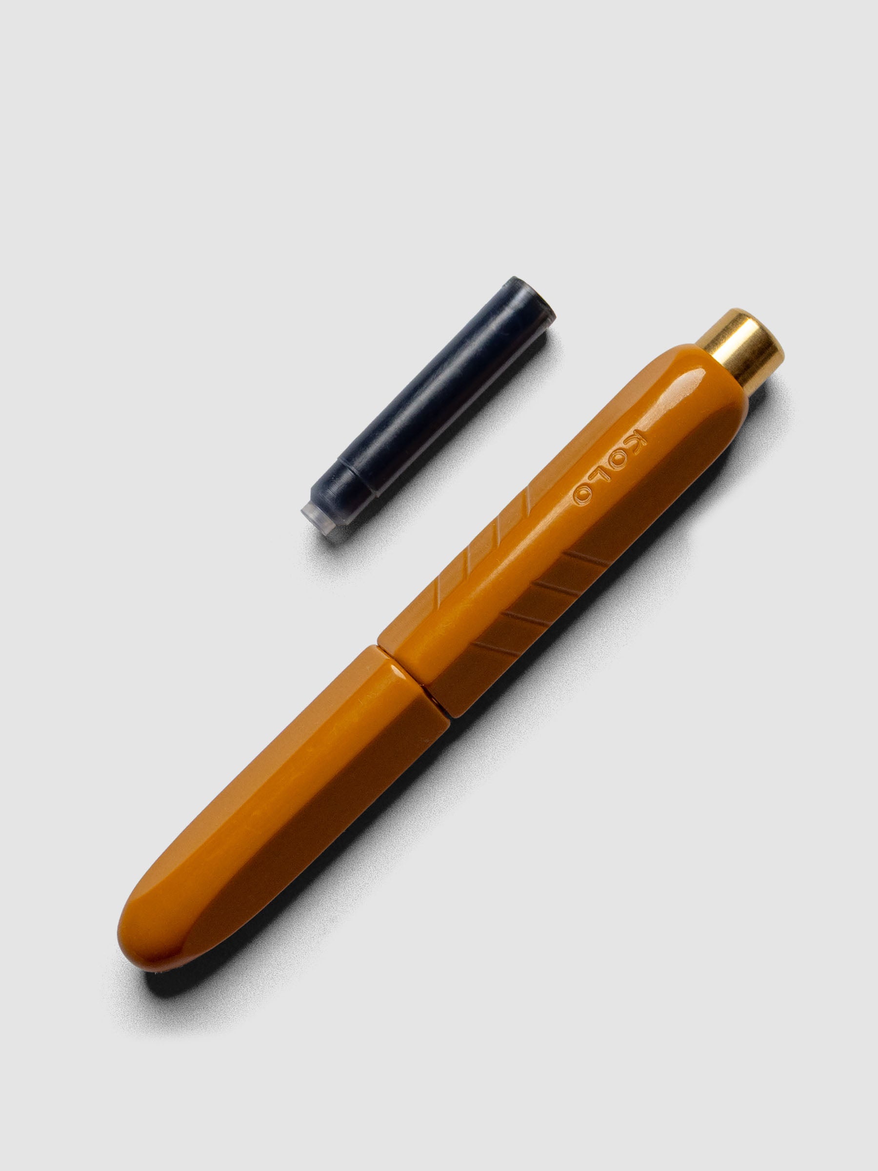 Kolo Tino Fountain Pen in the color Acrylic Sunny, shown cap on with ink cartridge resting beside pen.