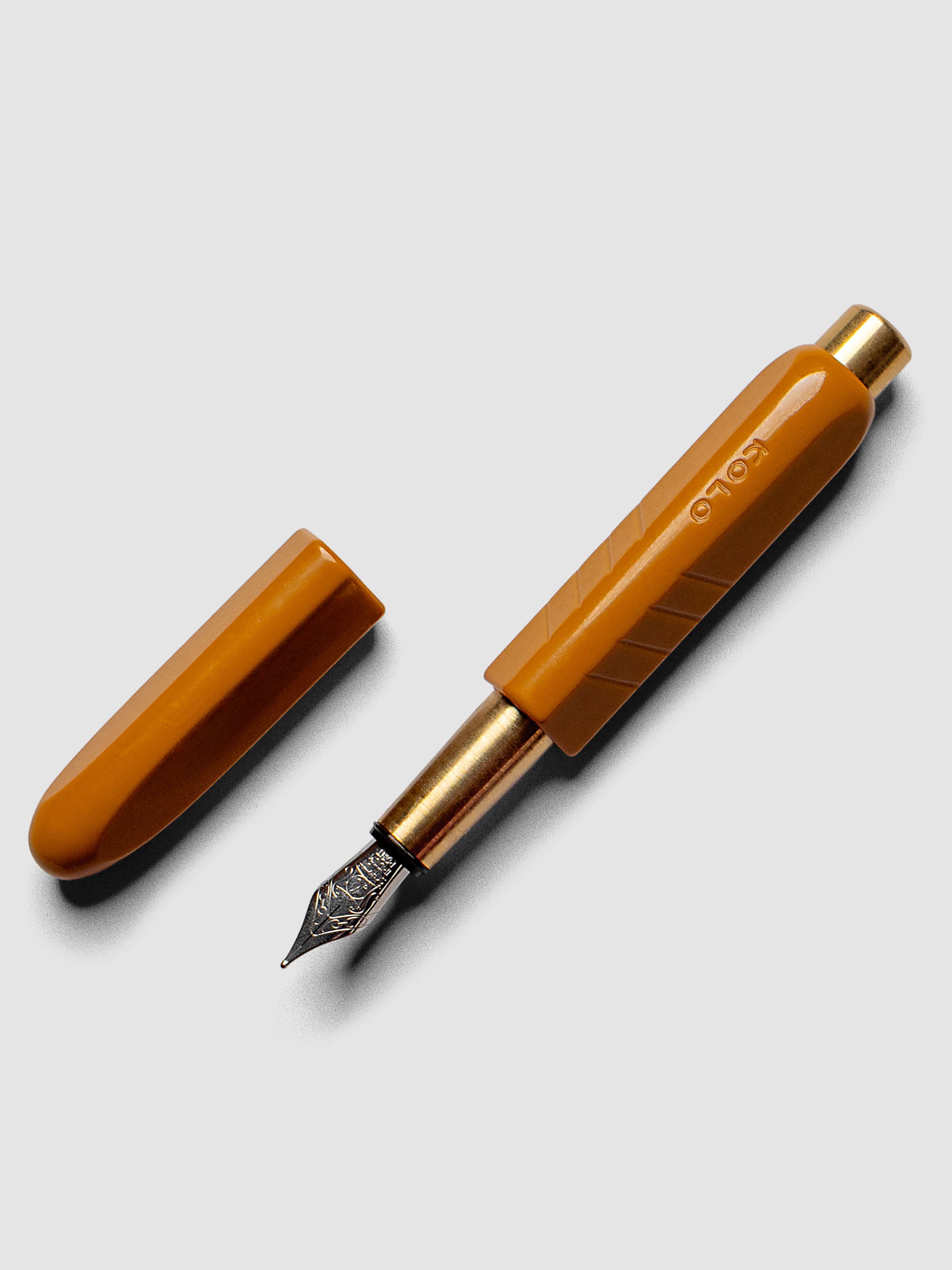 Kolo Tino Fountain Pen in the color Acrylic Sunny, a golden yellow with brass accents and a silver medium nib shown with cap off.