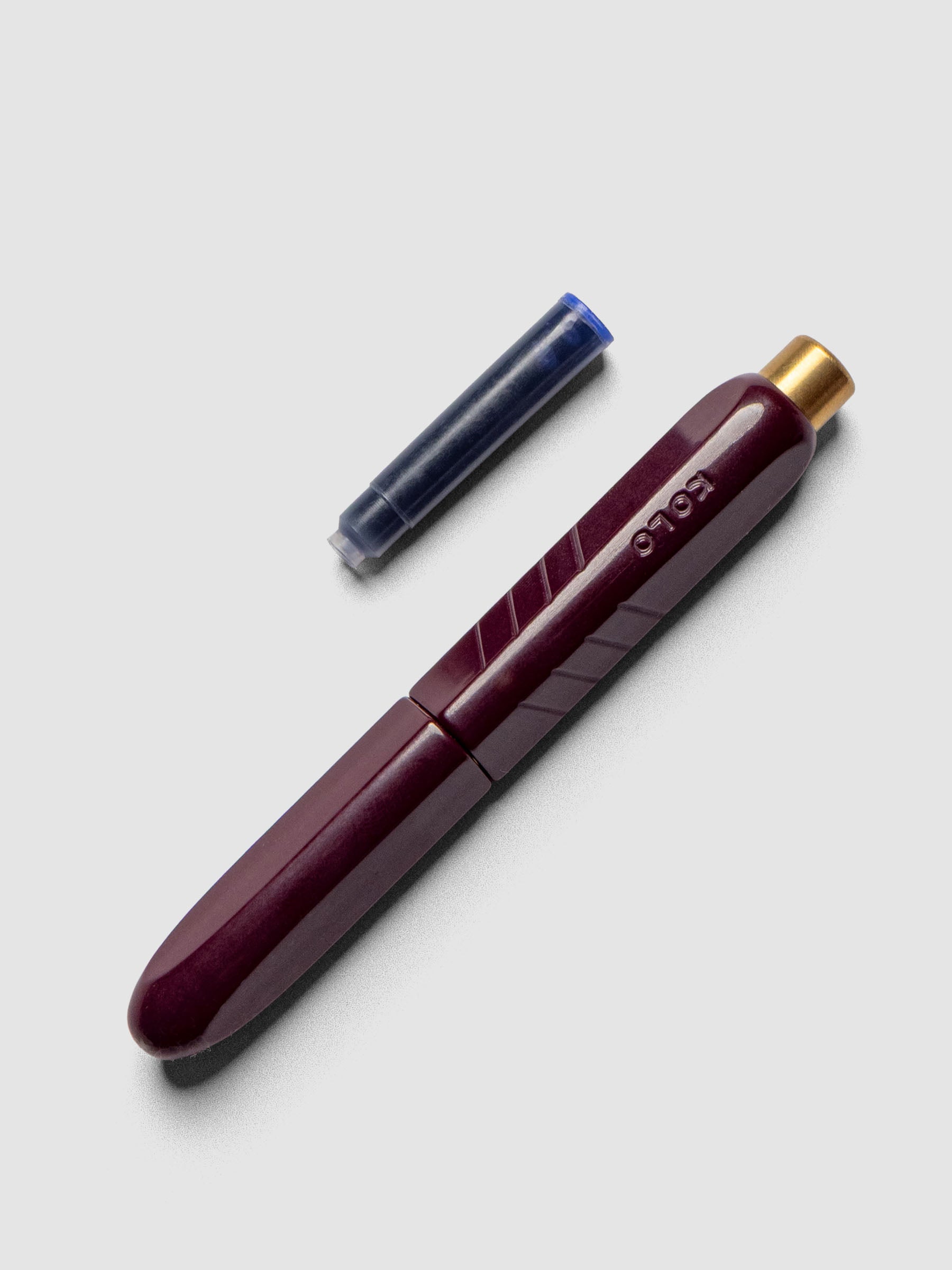 Kolo Tino Fountain Pen in the color Acrylic Cabaret, shown cap on with ink cartridge resting beside pen.