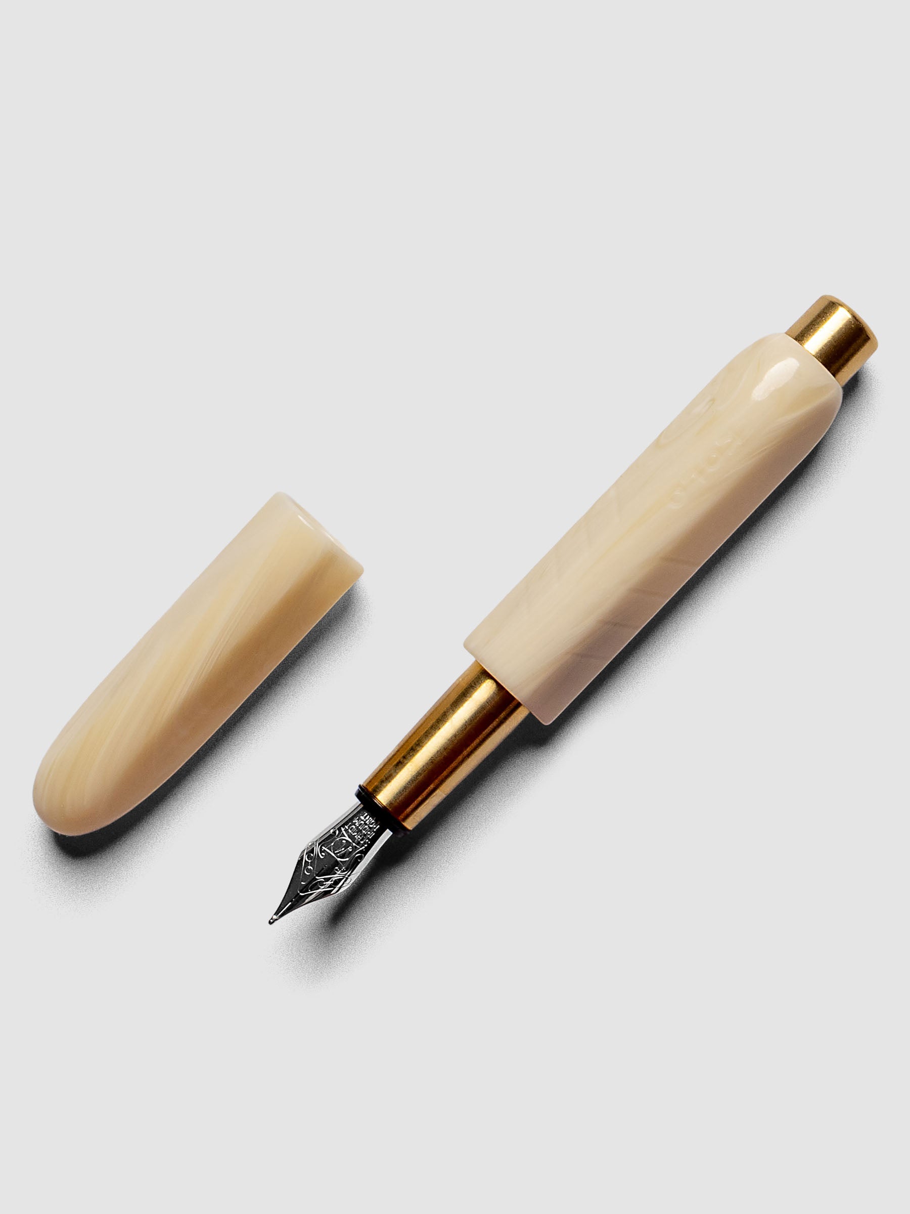 Kolo Tino Fountain Pen in the color Mother, a warm beige barrel with brass accents and a silver medium nib shown with cap off.
