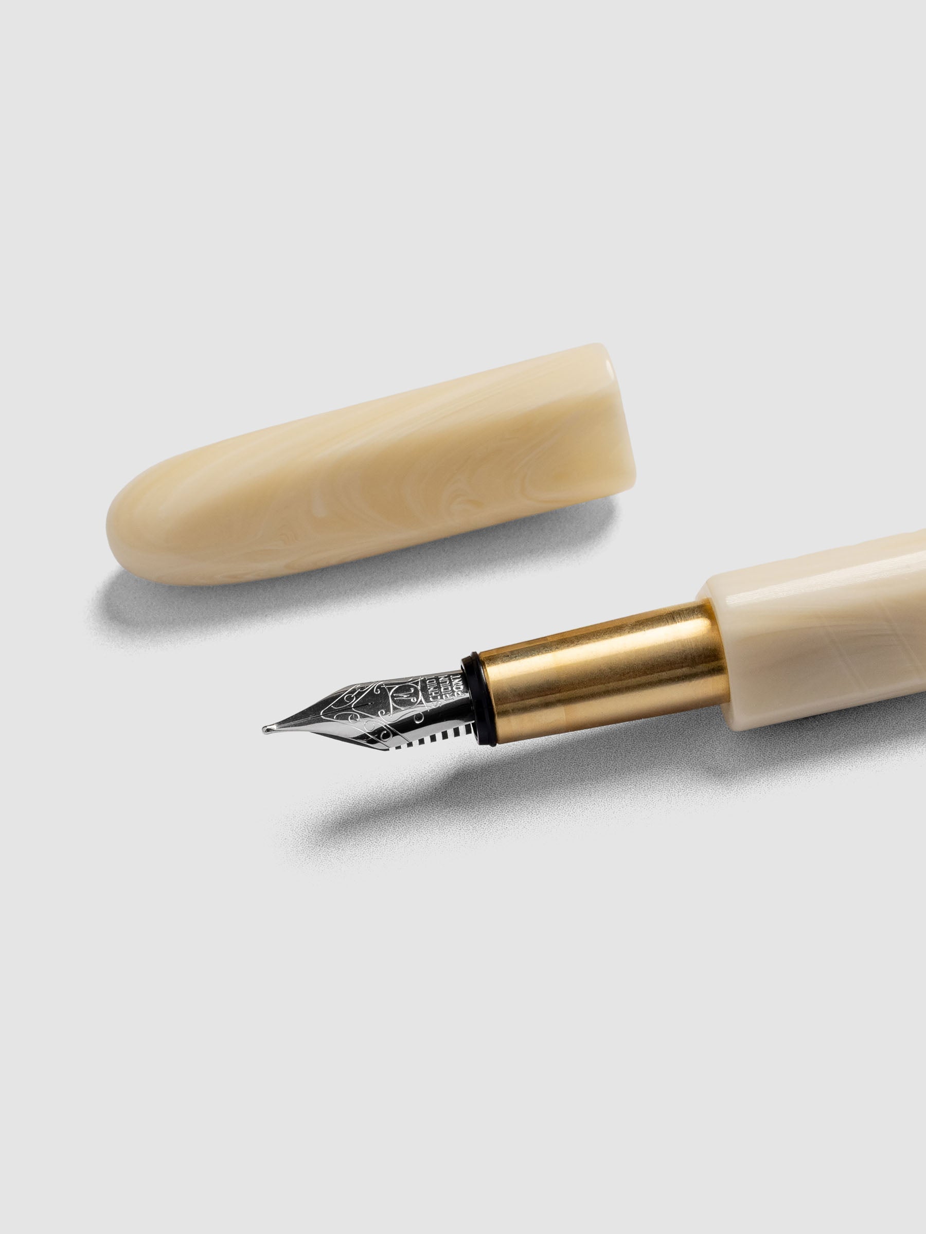 Kolo Tino Fountain Pen in the color Mother, a warm beige barrel with brass accents and a silver medium nib shown with cap off.