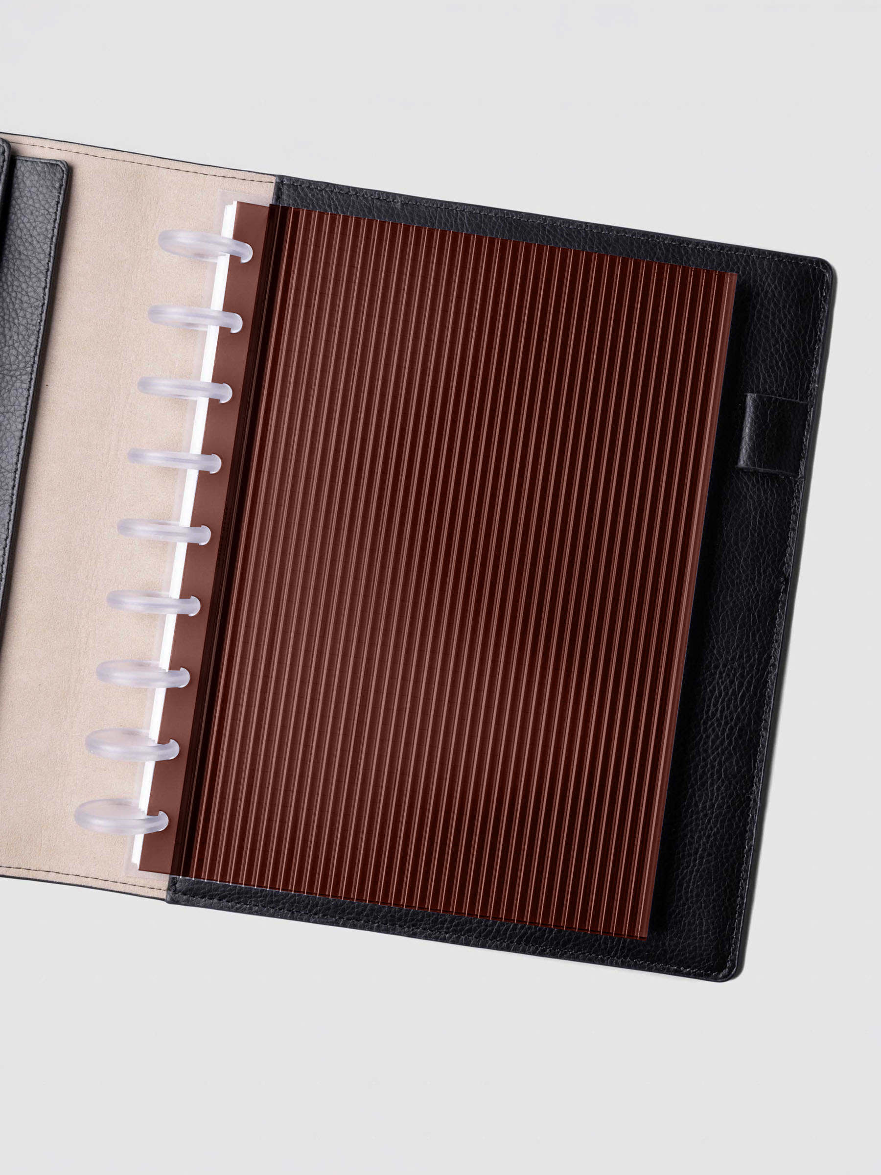 Bordeaux fluted planner dashboard in HP Classic size shown in a black leather discbound cover with clear discs.