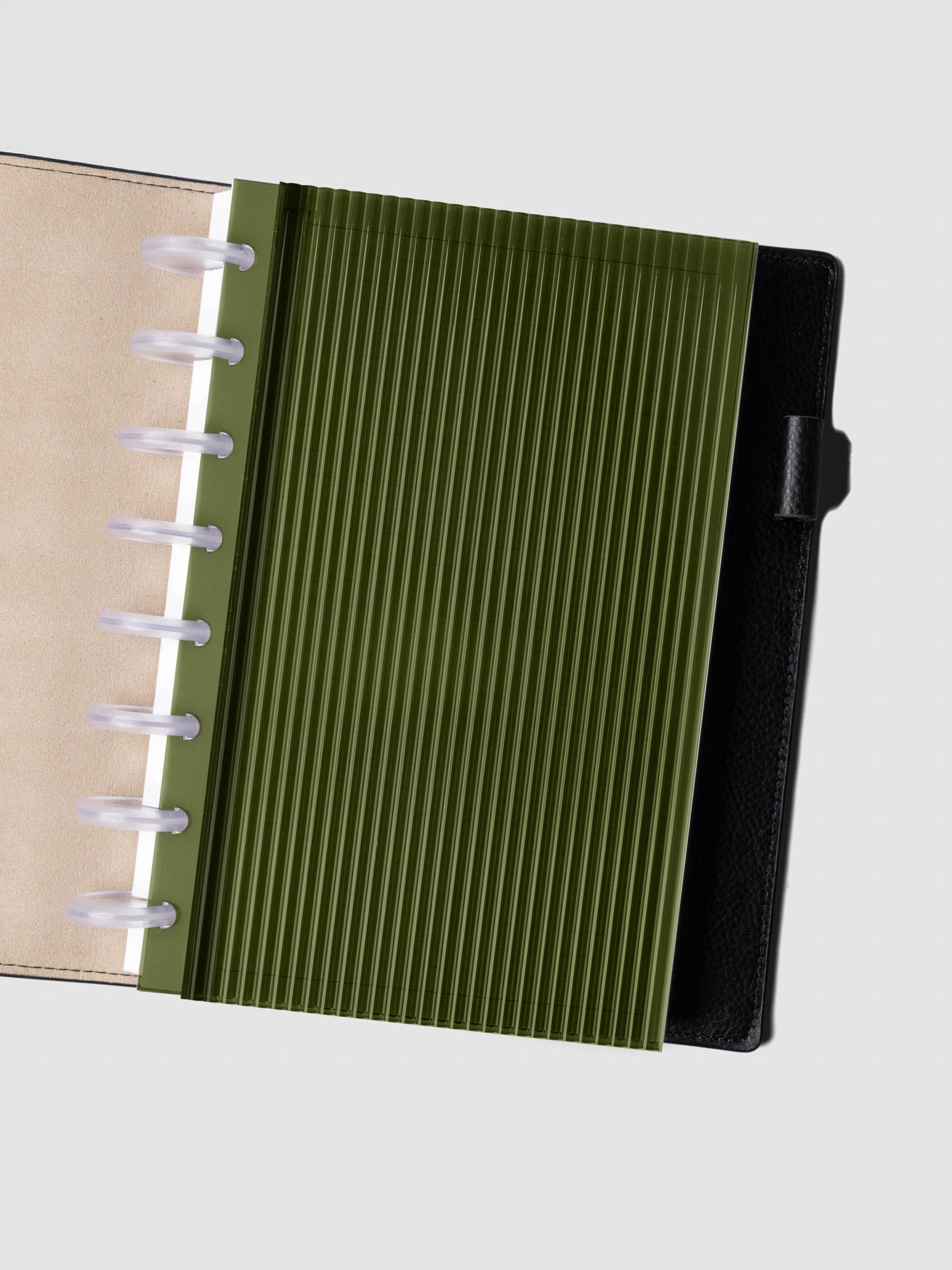 Olive fluted planner dashboard in Half Letter size shown in a black leather discbound cover with clear discs.