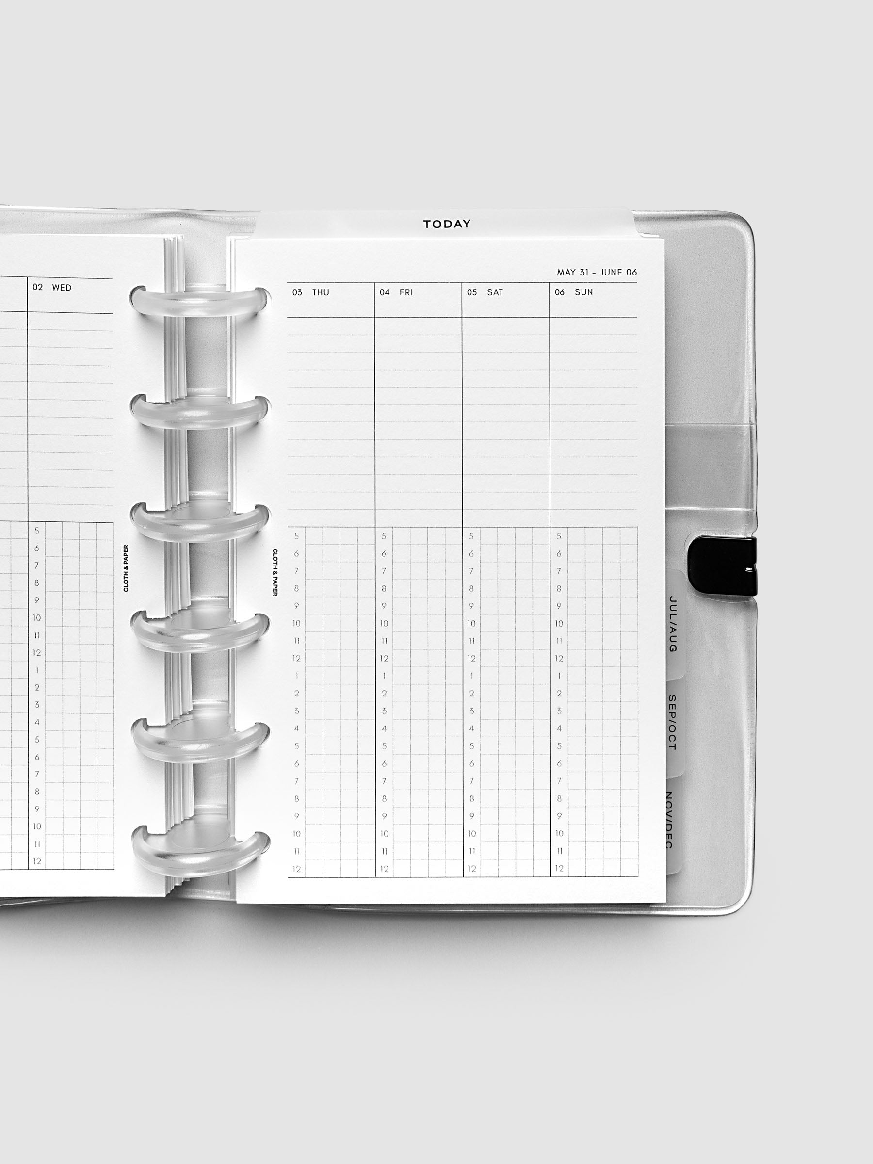Close-up of an open planner with clear 6-disc binding, weekly time block spread showing Thursday through Sunday columns with a task list above and an hourly grid below, tabbed monthly dividers visible at the edge, CP Petite 6-Disc Punch size