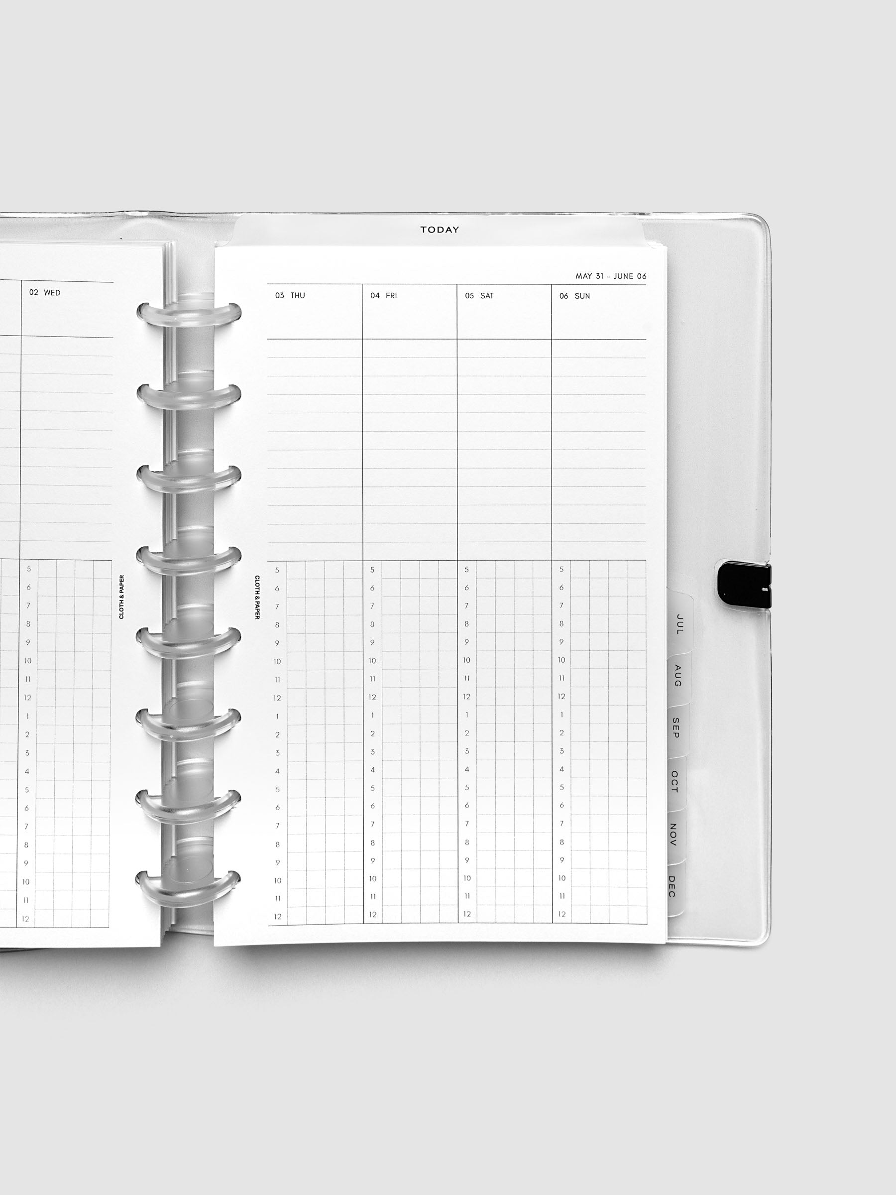 Close-up of an open planner with clear 8-disc binding, weekly time block spread showing Thursday through Sunday columns with a task list above and an hourly grid below, tabbed monthly dividers visible at the edge, Half Letter 8-Disc Punch size