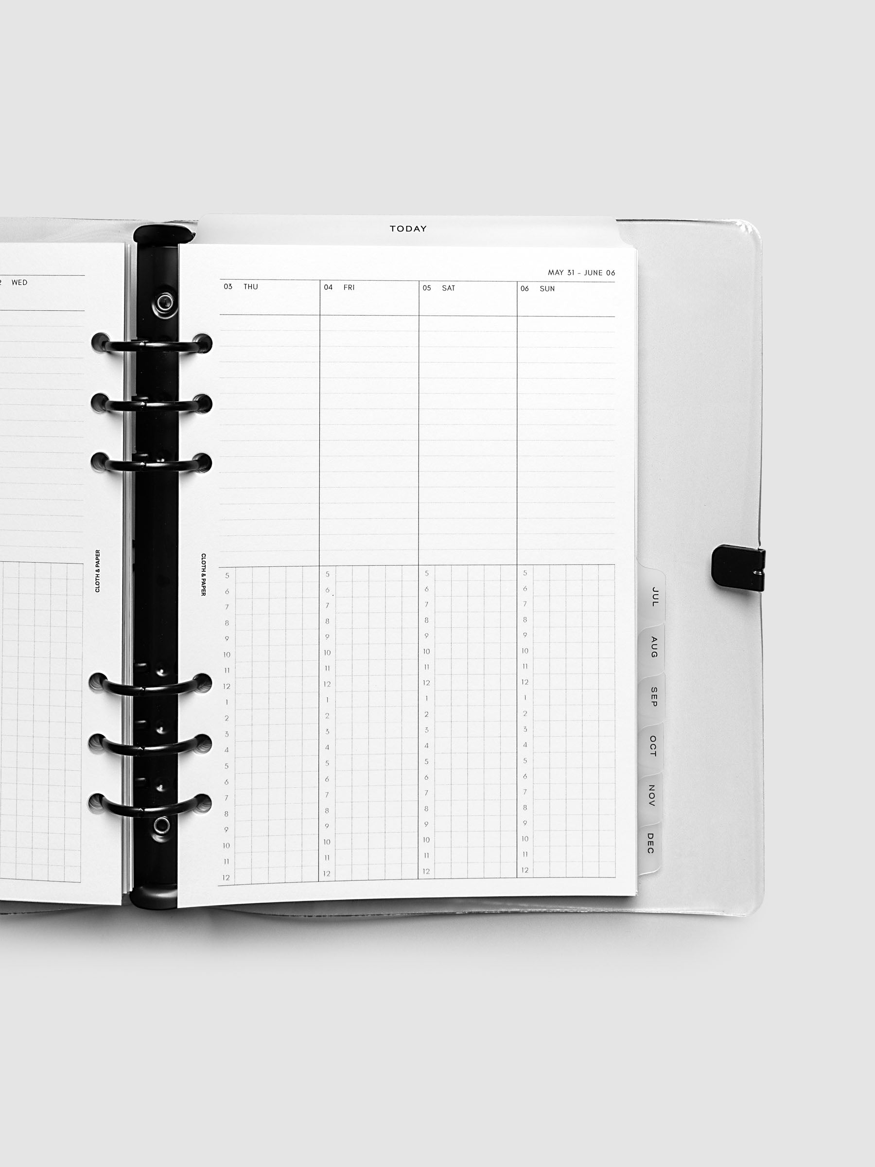 Close-up of an open planner with black 6-ring binding, weekly time block spread showing Thursday through Sunday columns with a task list above and an hourly grid below, tabbed monthly dividers visible at the edge, A5 6-Ring Punch sized