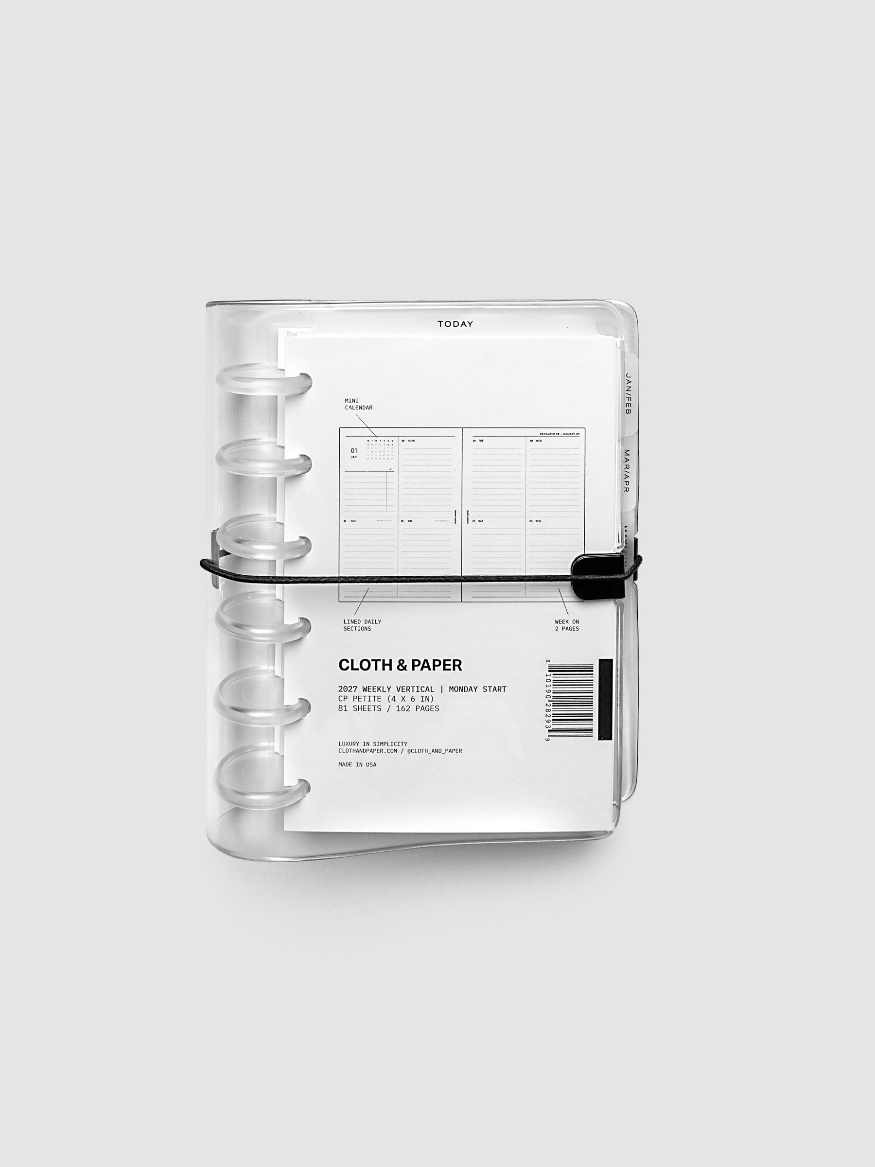 Closed clear vinyl planner cover with clear 6-disc binding and a black elastic closure, front page displaying a labeled weekly vertical spread with mini calendar, lined daily sections, and week on two pages callouts, CP Petite 6-Disc Punch size