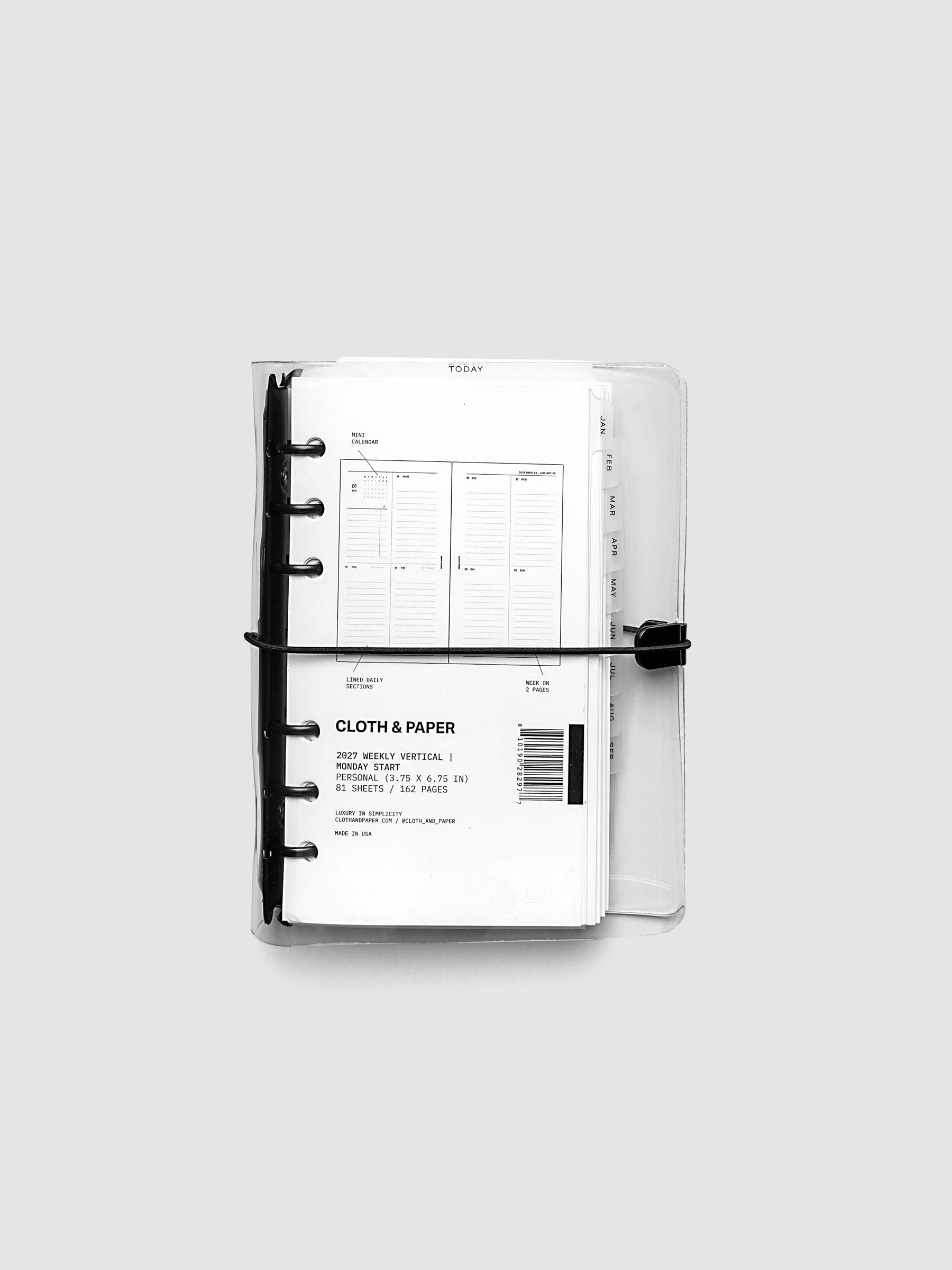 Closed clear vinyl planner cover with black 6-ring binding and a black elastic closure, front page displaying a labeled weekly vertical spread with mini calendar, lined daily sections, and week on two pages callouts, Personal 6-Ring Punch size