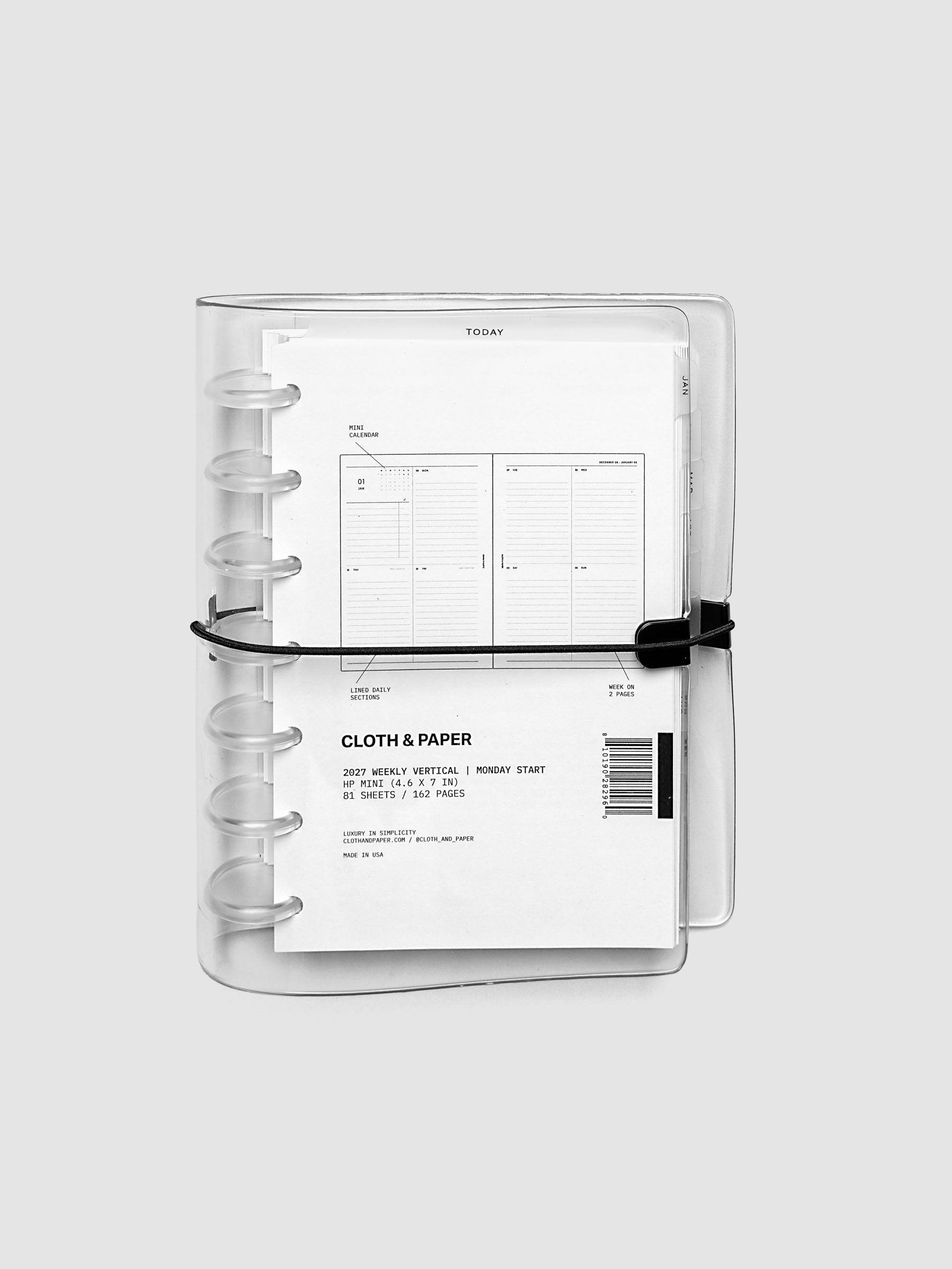 Closed clear vinyl planner cover with clear 7-disc binding and a black elastic closure, front page displaying a labeled weekly vertical spread with mini calendar, lined daily sections, and week on two pages callouts, HP Mini 7-Disc Punch size