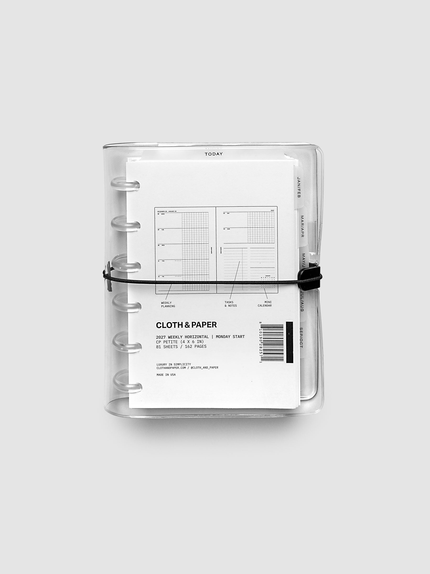Closed clear vinyl planner cover with clear 6-disc binding and a black elastic closure, front page displaying a labeled weekly horizontal spread with weekly planning, tasks and notes, and mini calendar callouts, CP Petite 6-Disc Punch size