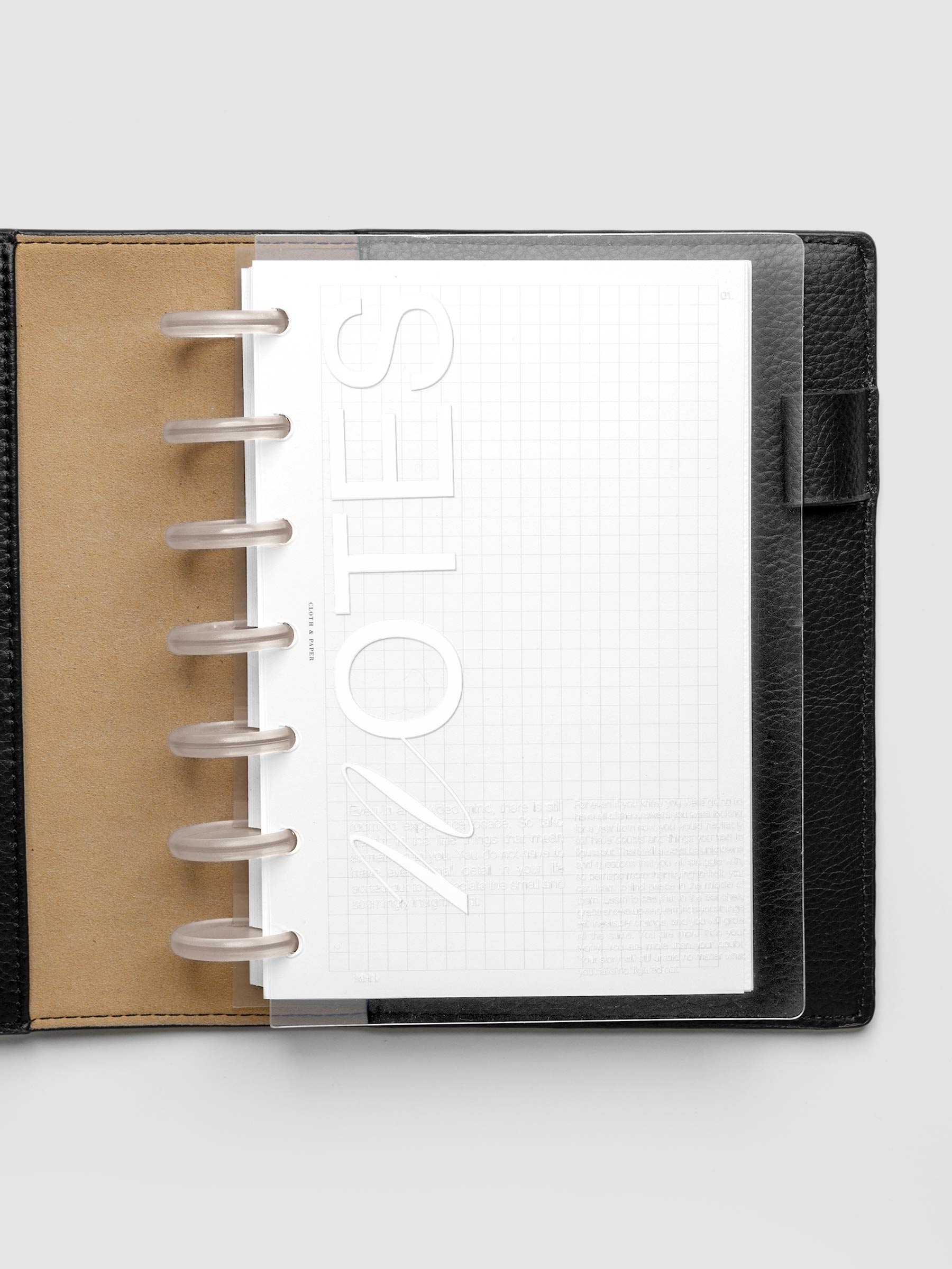 Clear plastic planner cover with white printed text shown pre-punched for HP Mini discbound planners in a black folio.