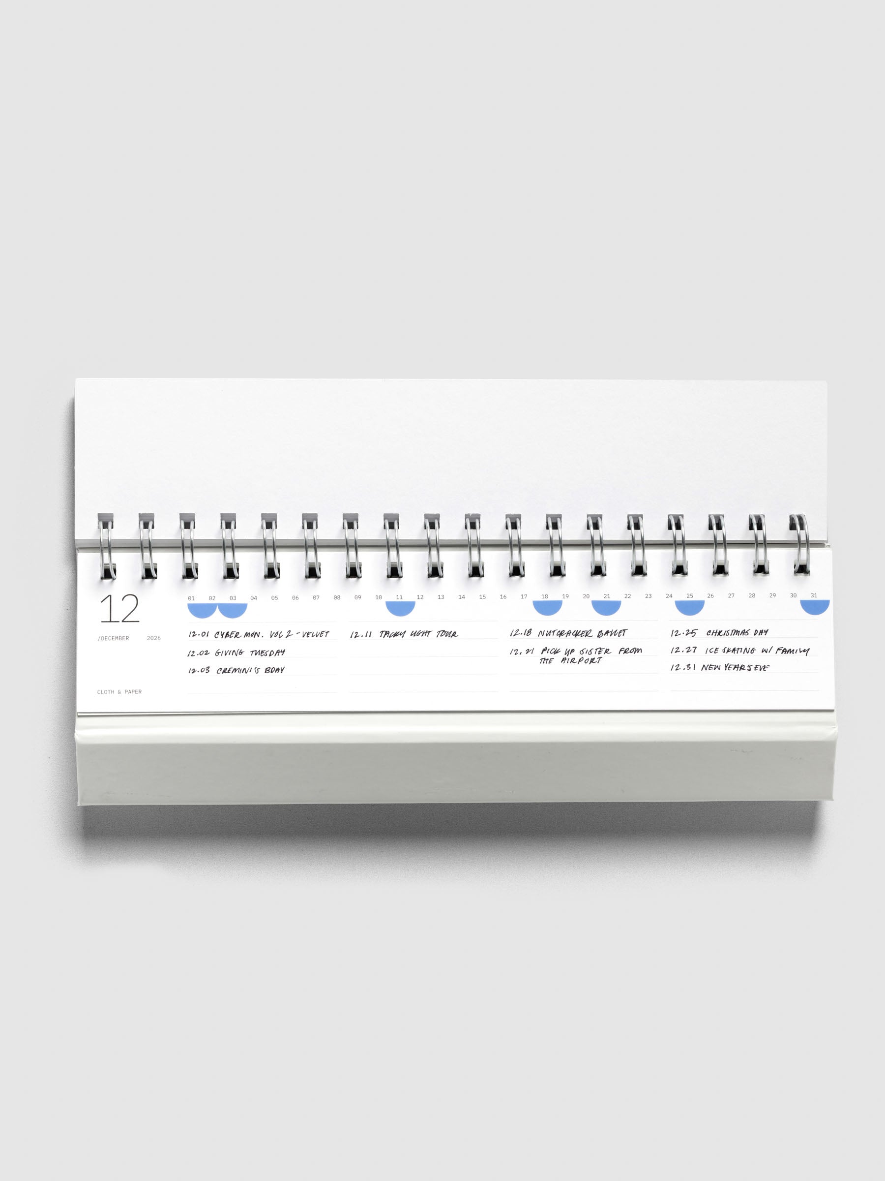 2026 Spiral Desk Calendar shown displaying a calendar page with stickers and handwritten notes.