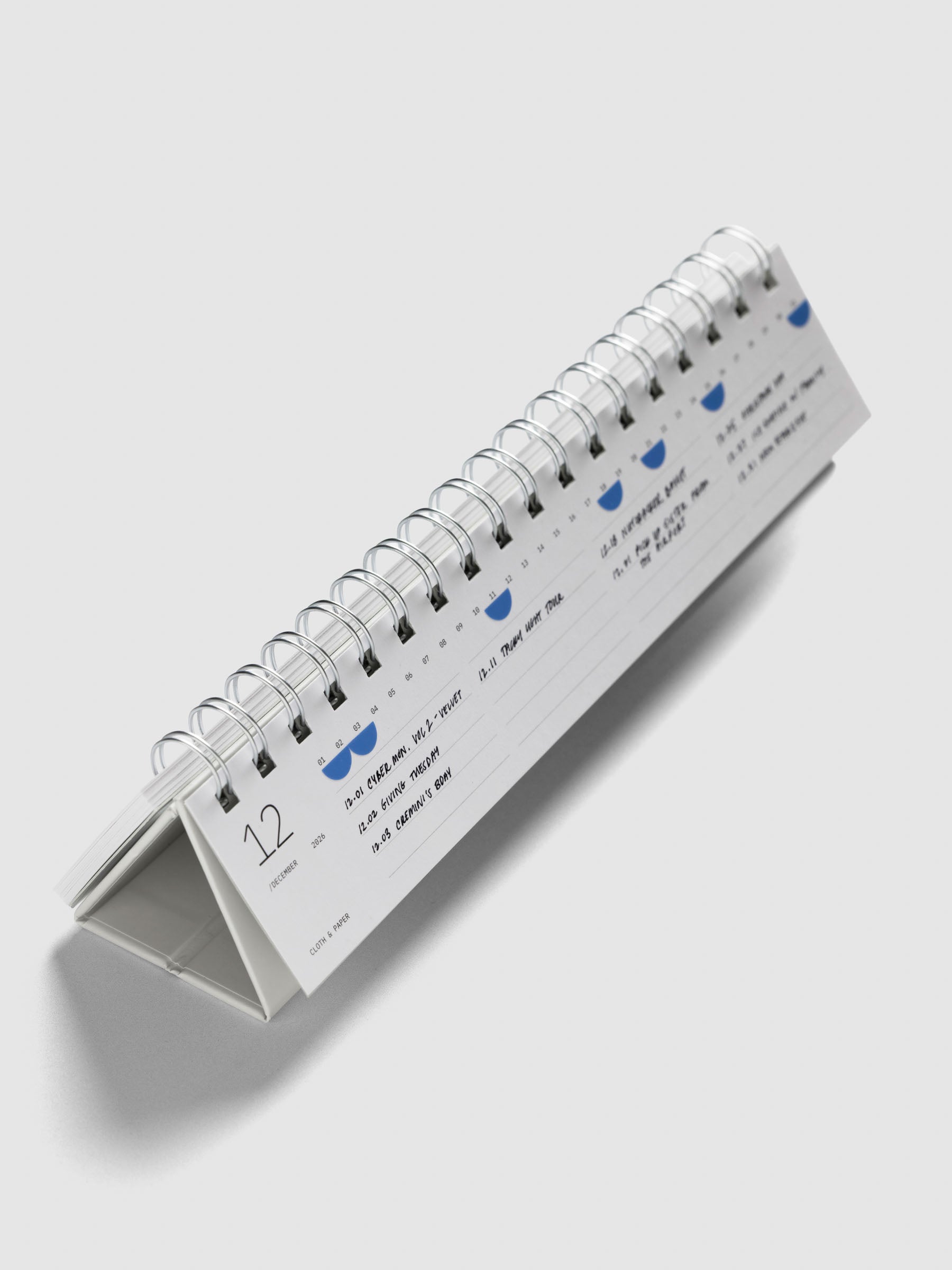 2026 Spiral Desk Calendar shown standing displaying a calendar page with stickers and handwritten notes.