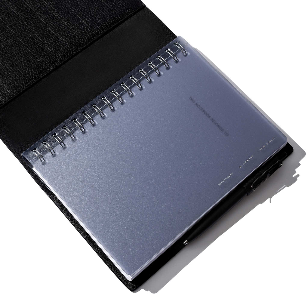 Tinted plastic notebook displayed in a black leather folio.