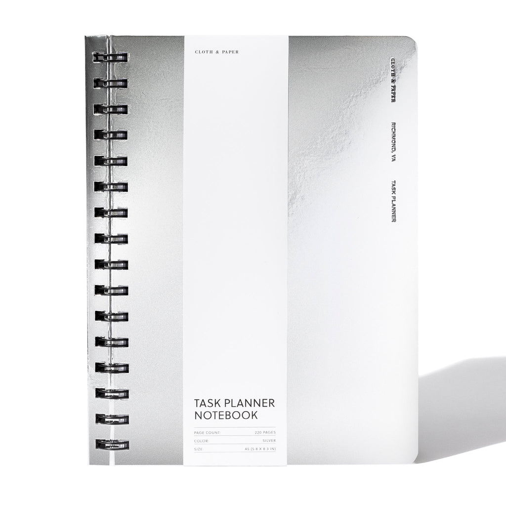 Exotic Spiral Notebook, A5, Silver, Cloth and Paper. Silver notebook displayed with its packaging on a white background.