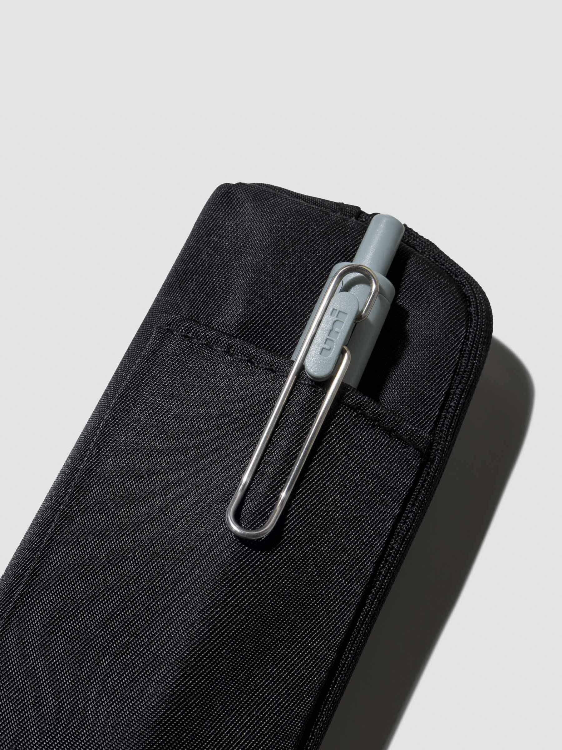 Uni Ball One pen displayed inside the external pocket of a notebook pouch. Color shown is Avant Garde.