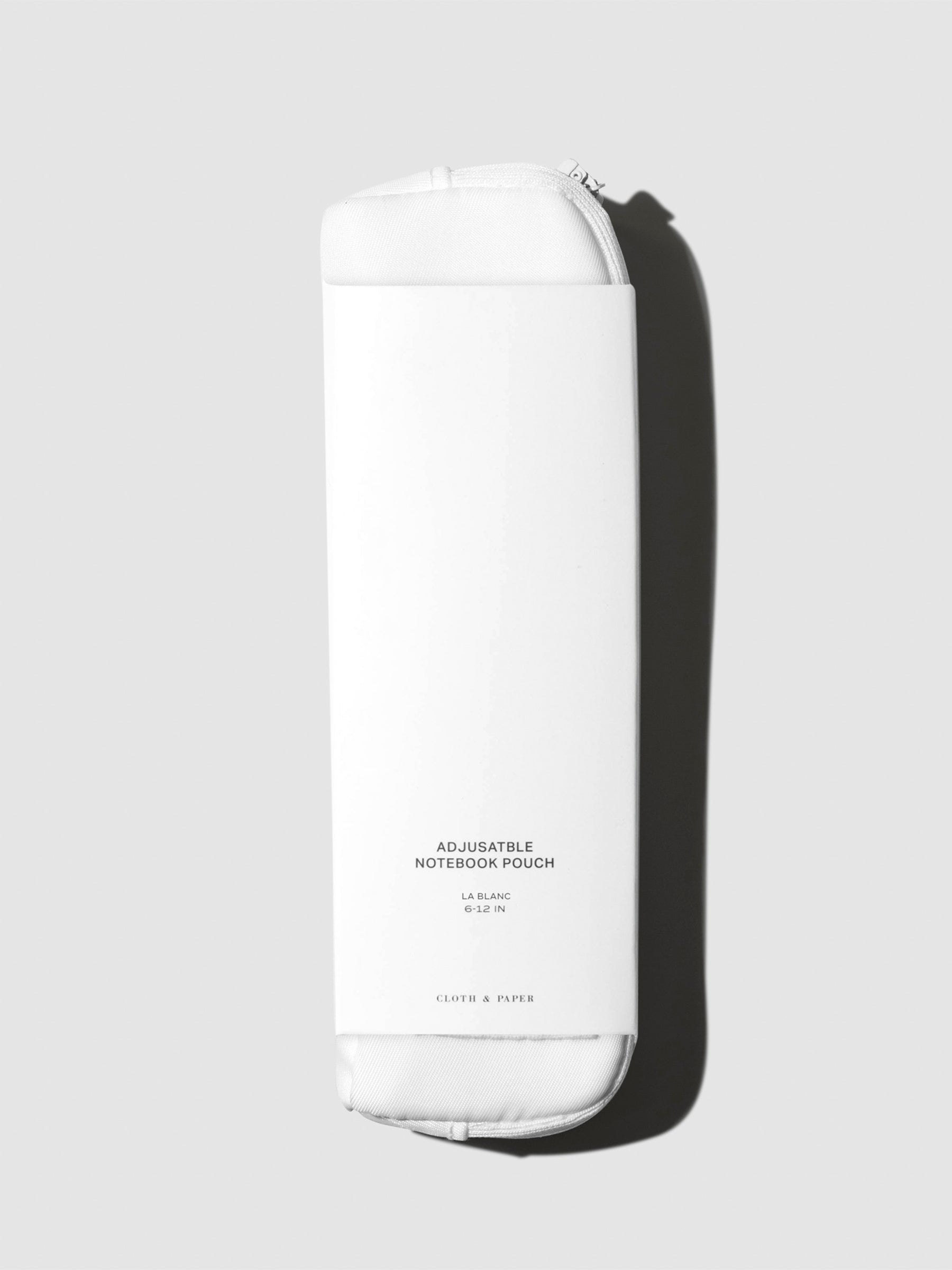 Notebook pouch displayed on a neutral background. Color shown is Le Blanc.