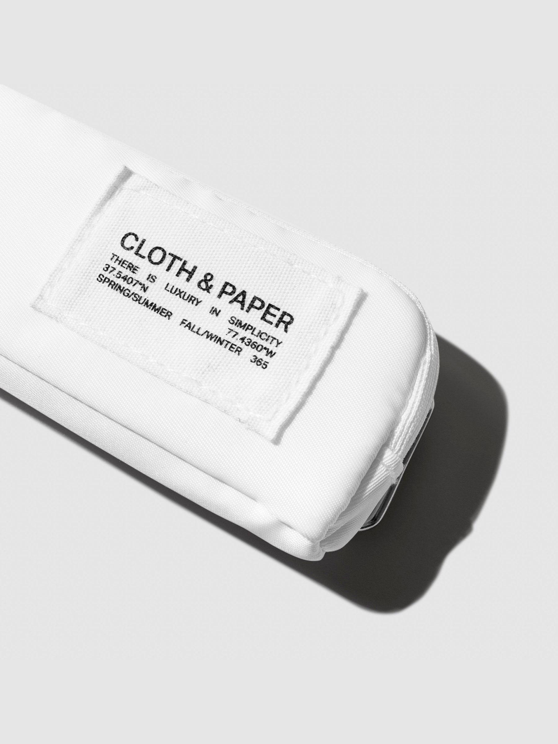 Closeup of Cloth and Paper tag on pouch. Color shown is Le Blanc.
