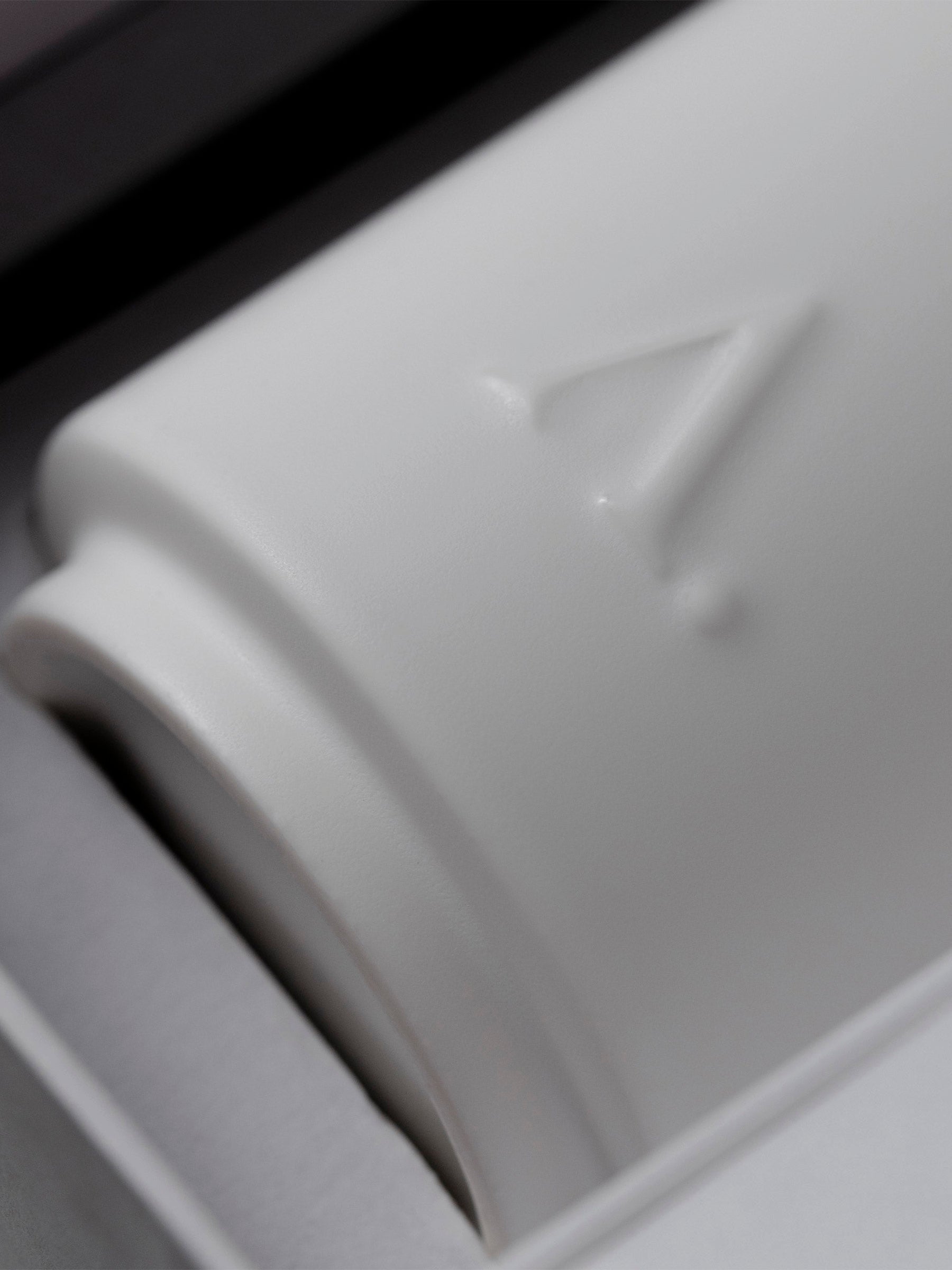 Closeup of Aesthete logo embossed onto the ceramic diffuser vessel.