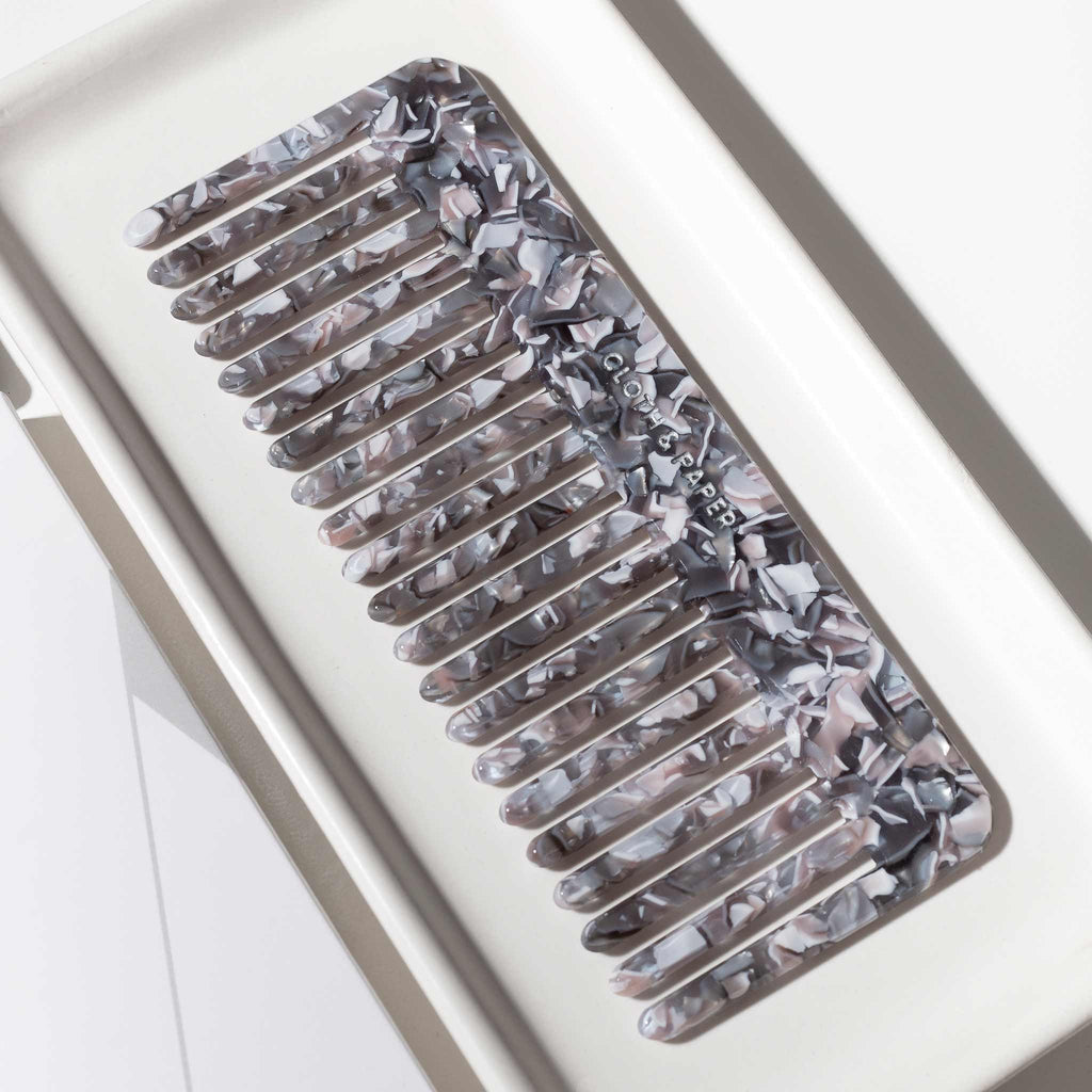 Comb resting on a tray, tilted slightly to the left 