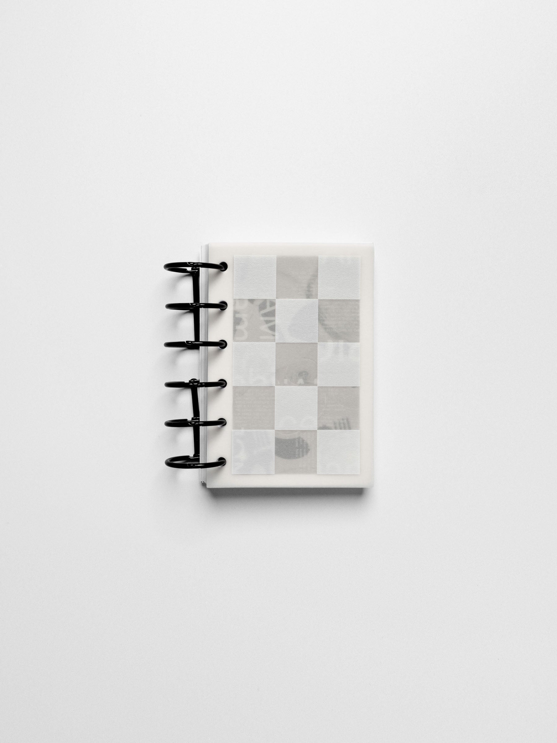 Ambiance Dashboard Trio assembled inside a compact Pocket sized ring-bound planner with black rings showing the grid layer on top.