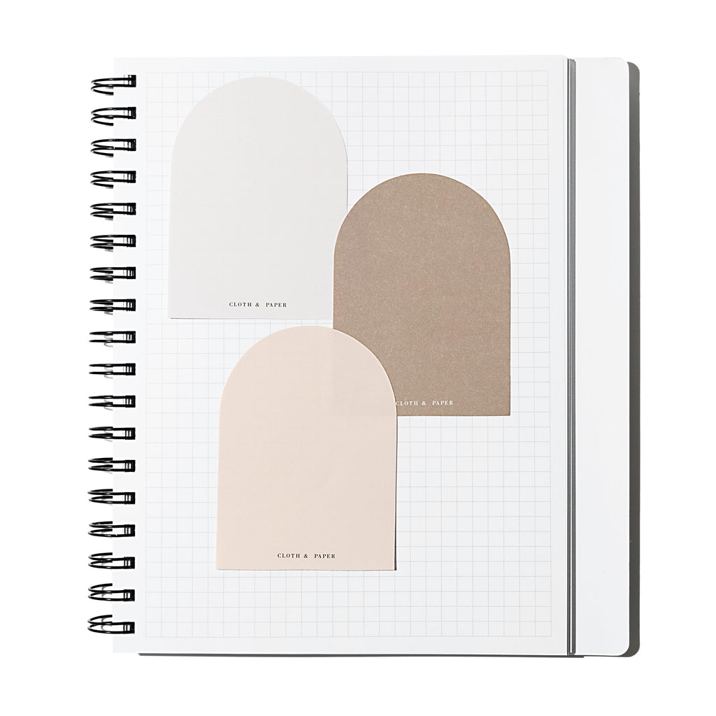 Angora, Beignet, and Cortado sticky notes layered over each other inside of a graph notebook on a white background.