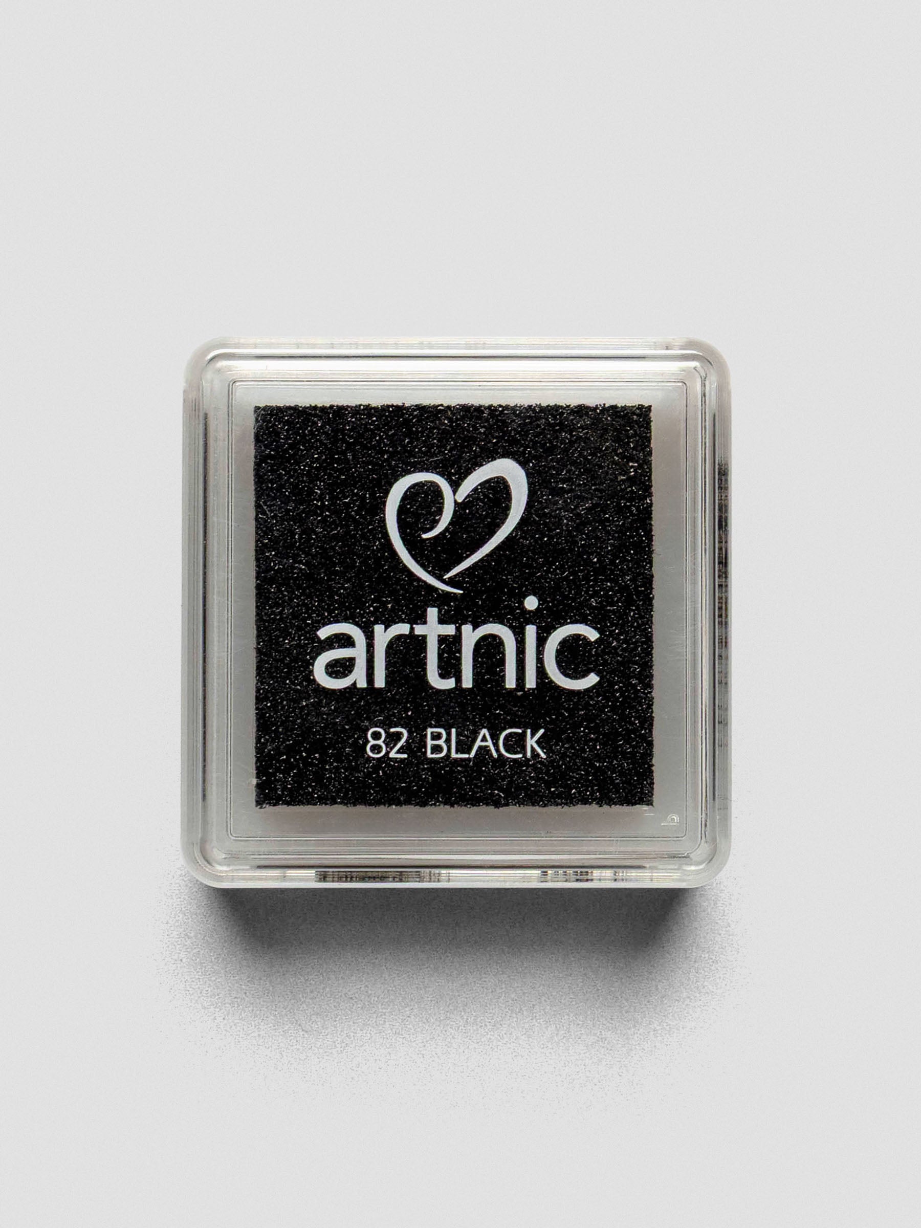 Top-down view of a closed Artnic stamp ink pad in black, with the color name and logo printed on the clear lid.