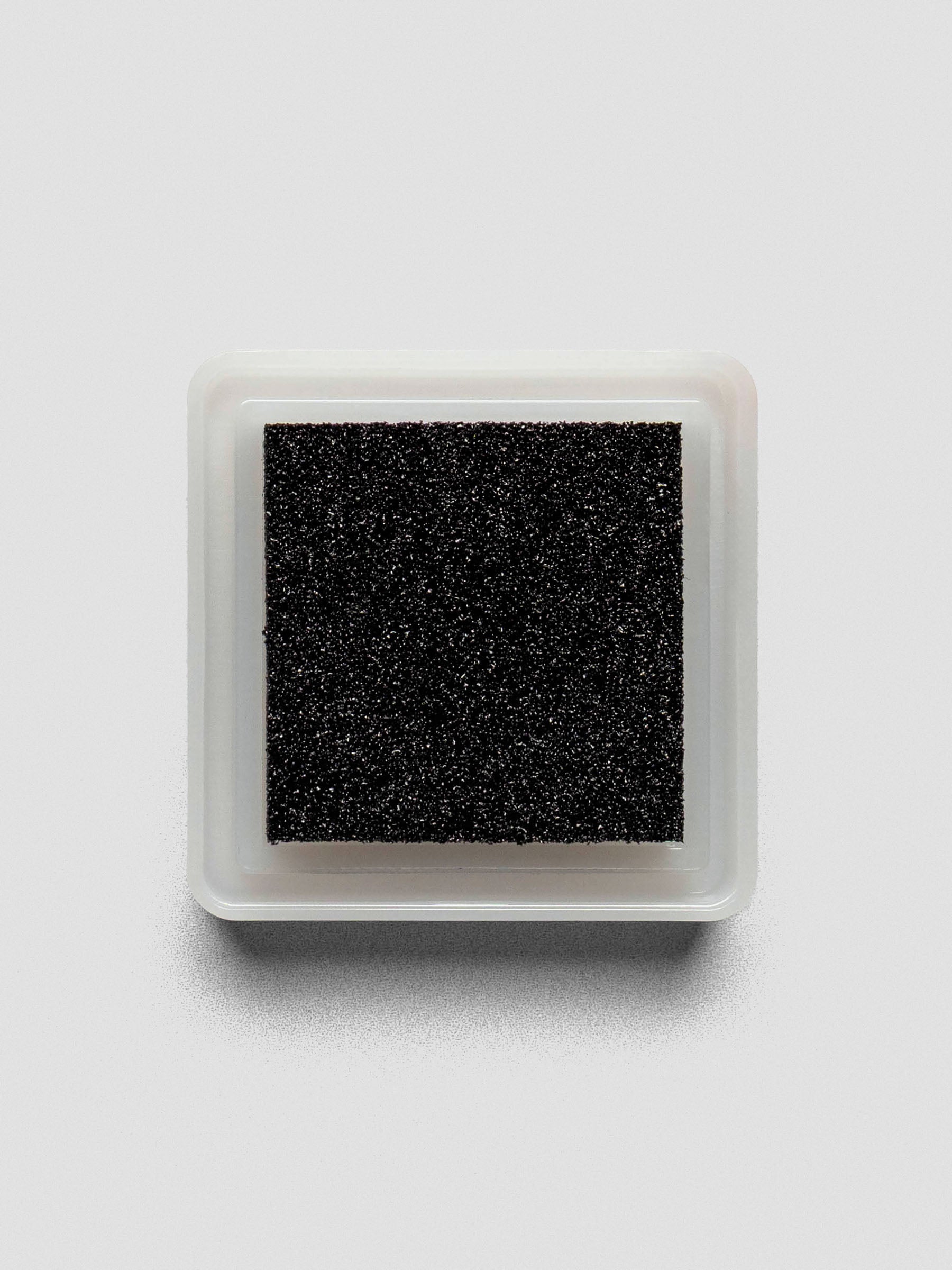 Black Artnic ink pad without lid, top-down view showing textured ink surface.