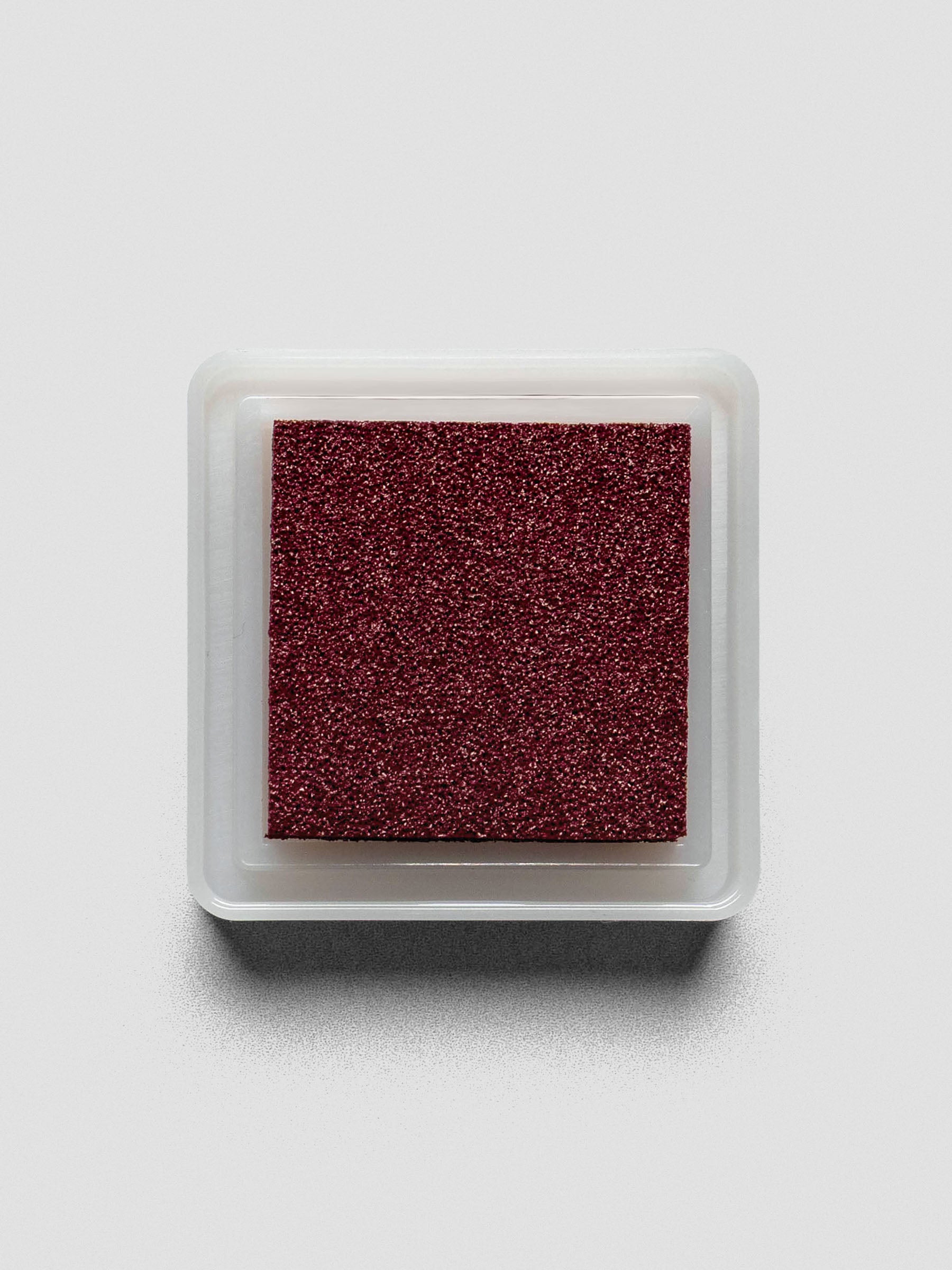 Burgundy Artnic ink pad without lid, top-down view showing textured ink surface.