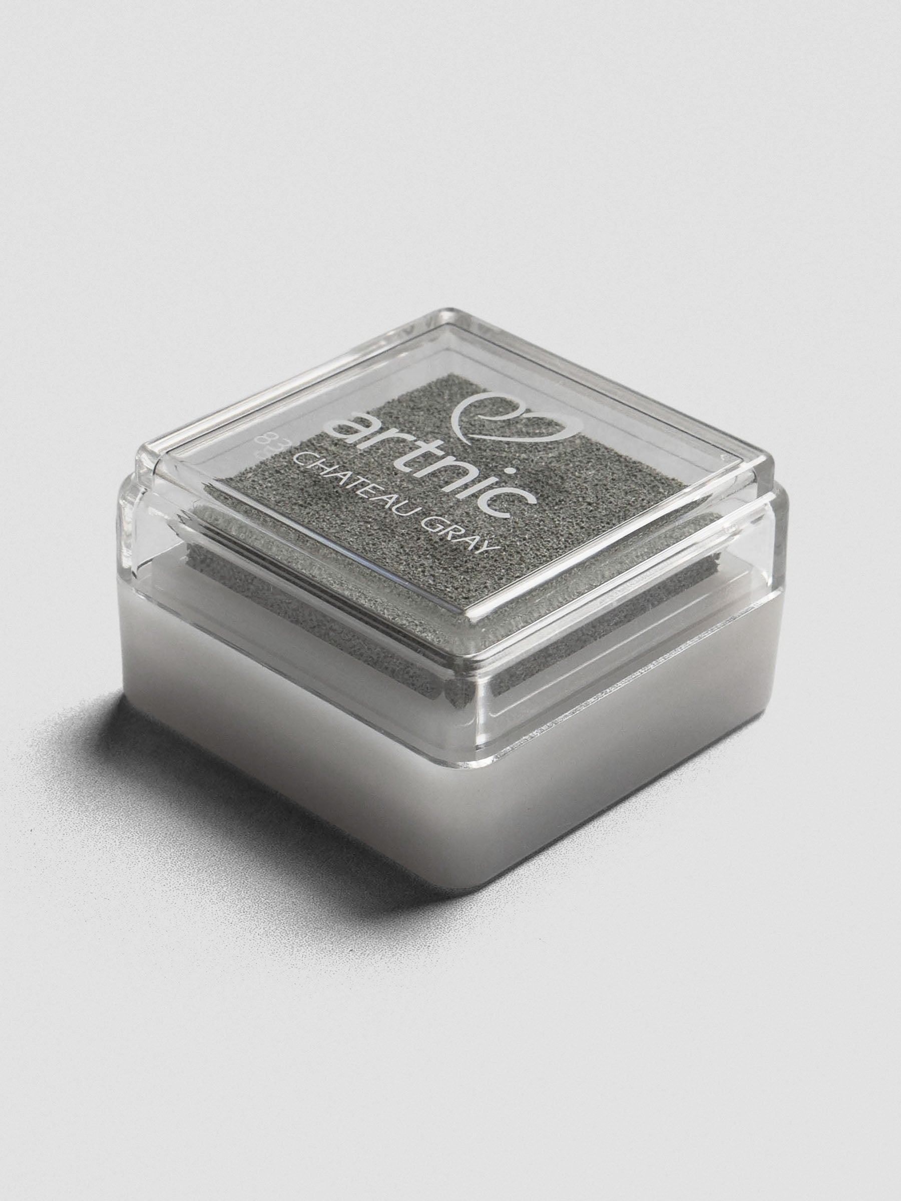 Gray Artnic ink pad with clear lid, angled view showing its stackable design.
