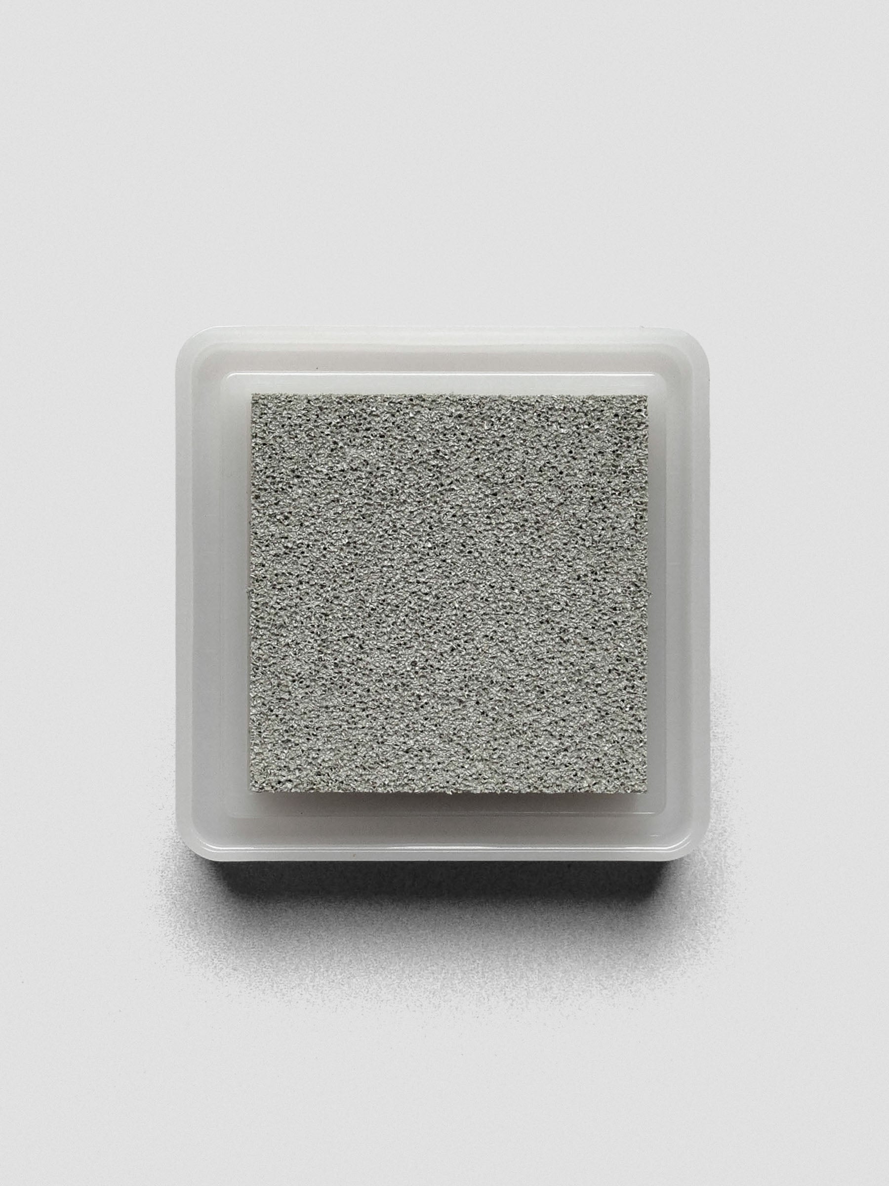 Gray Artnic ink pad without lid, top-down view showing textured ink surface.