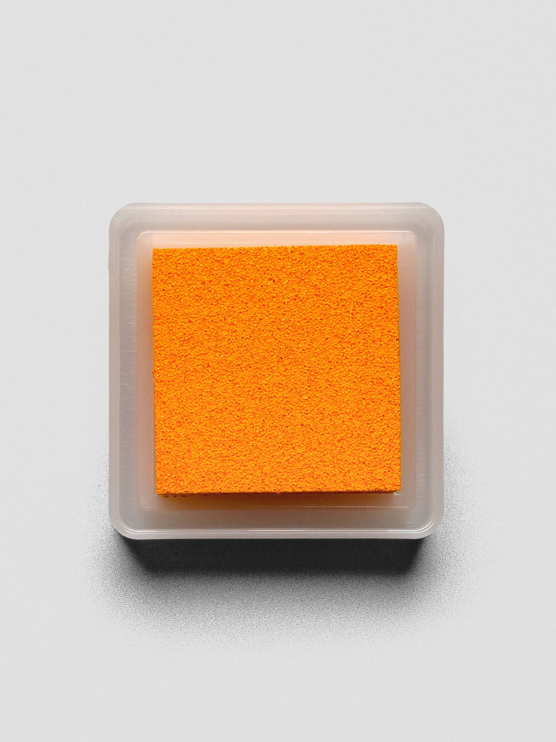 Top-down view of open Marigold ink pad showing textured bright orange surface.