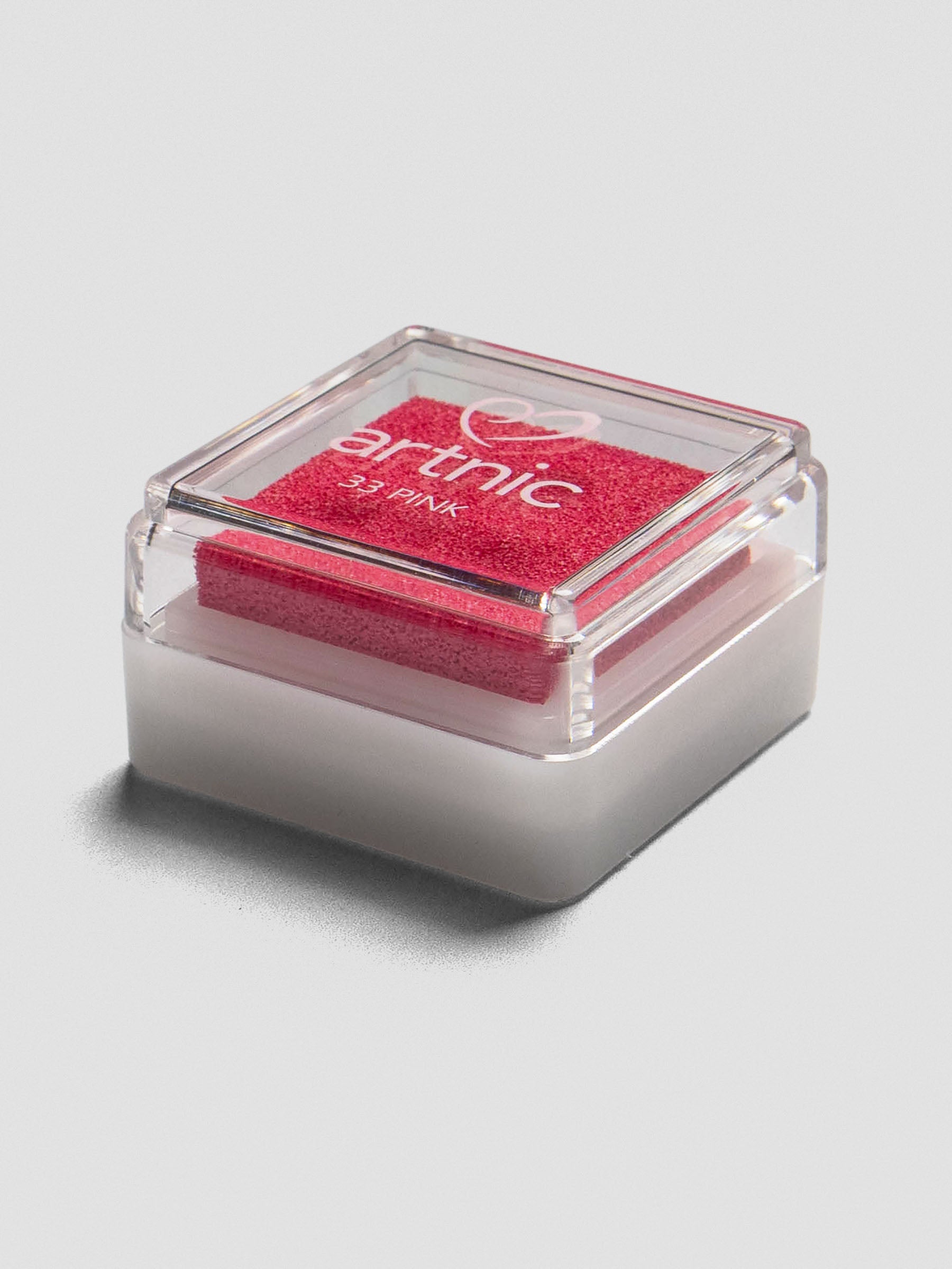 Pink Artnic ink pad with clear lid, angled view showing its stackable design.
