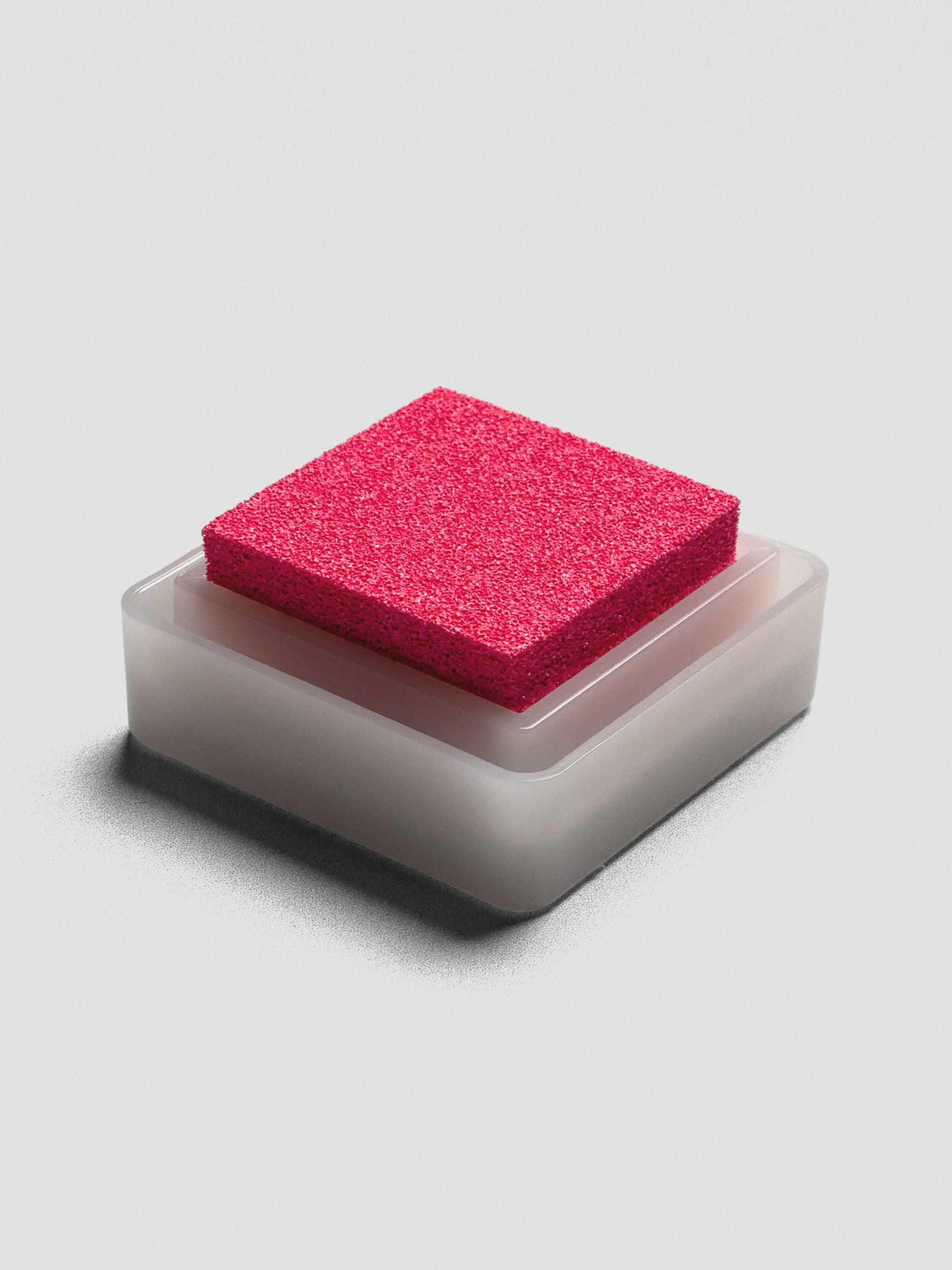 Pink Artnic ink pad without lid, angled view of textured ink surface and white base.