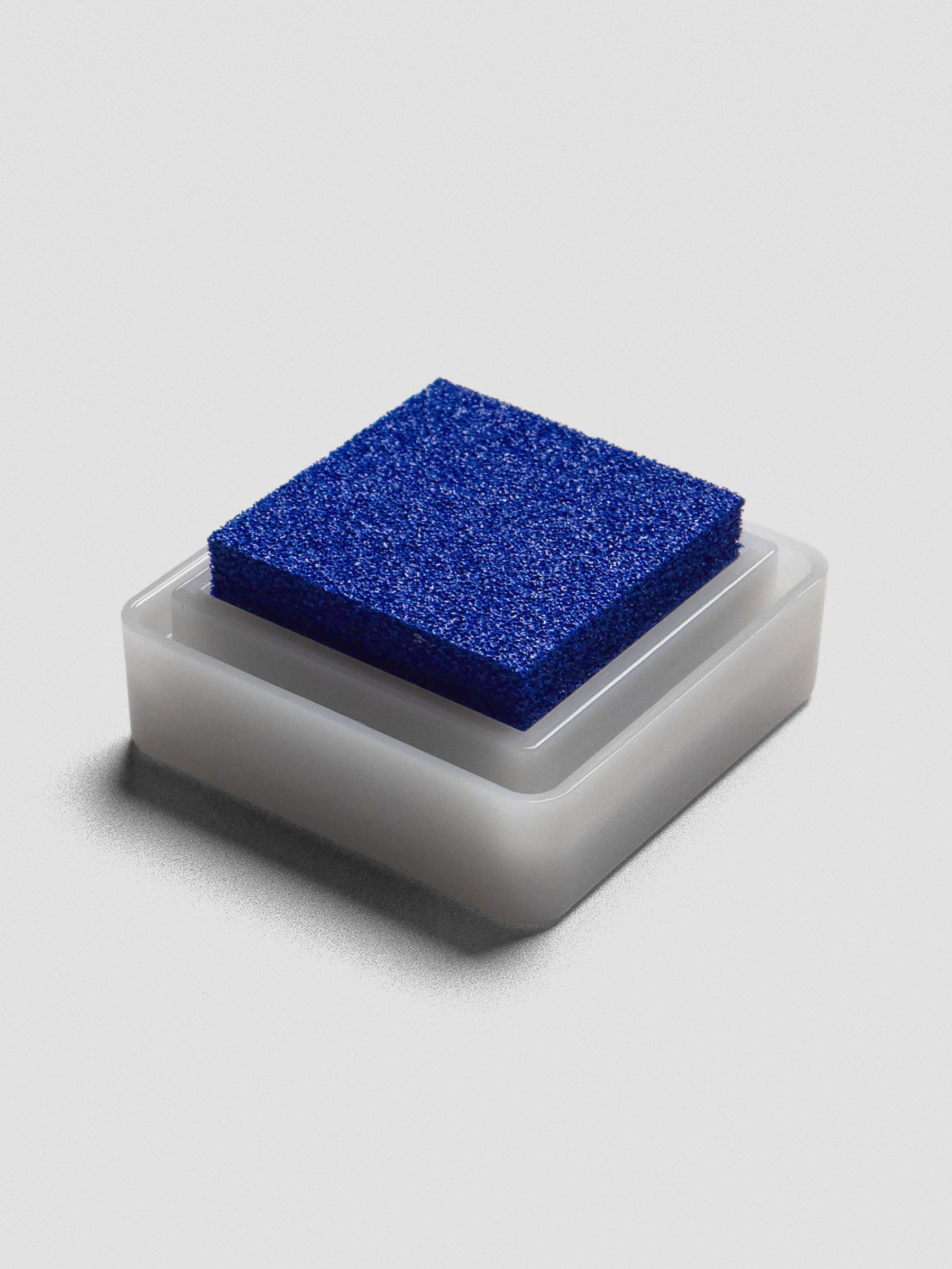 Blue Artnic ink pad without lid, angled view of textured ink surface and white base.