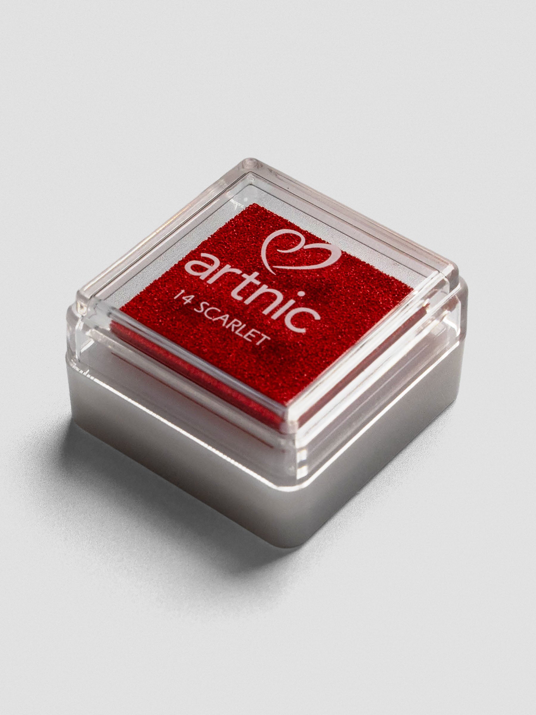 Red Artnic ink pad with clear lid, angled view showing its stackable design.
