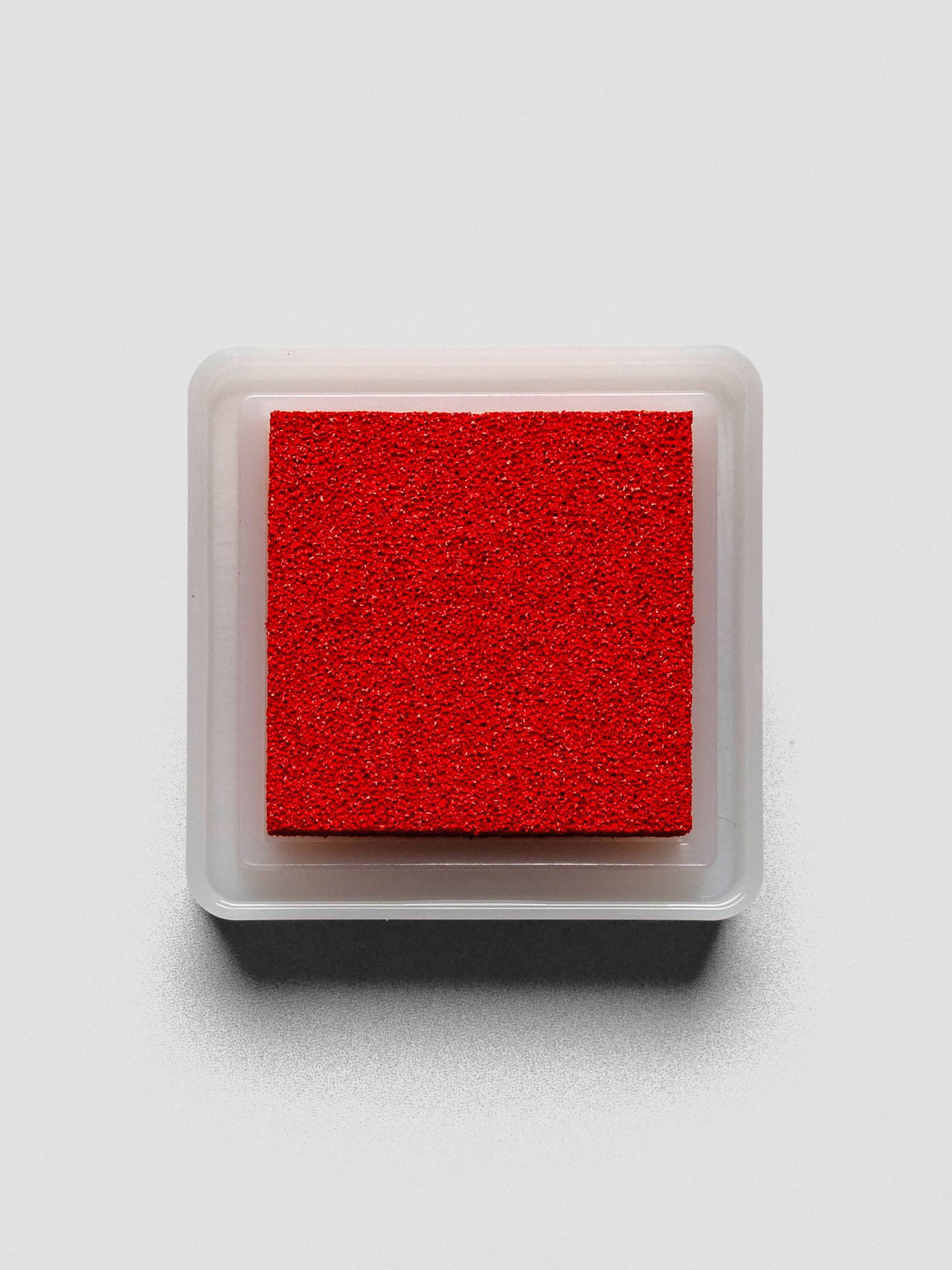 Red Artnic ink pad without lid, top-down view showing textured ink surface.