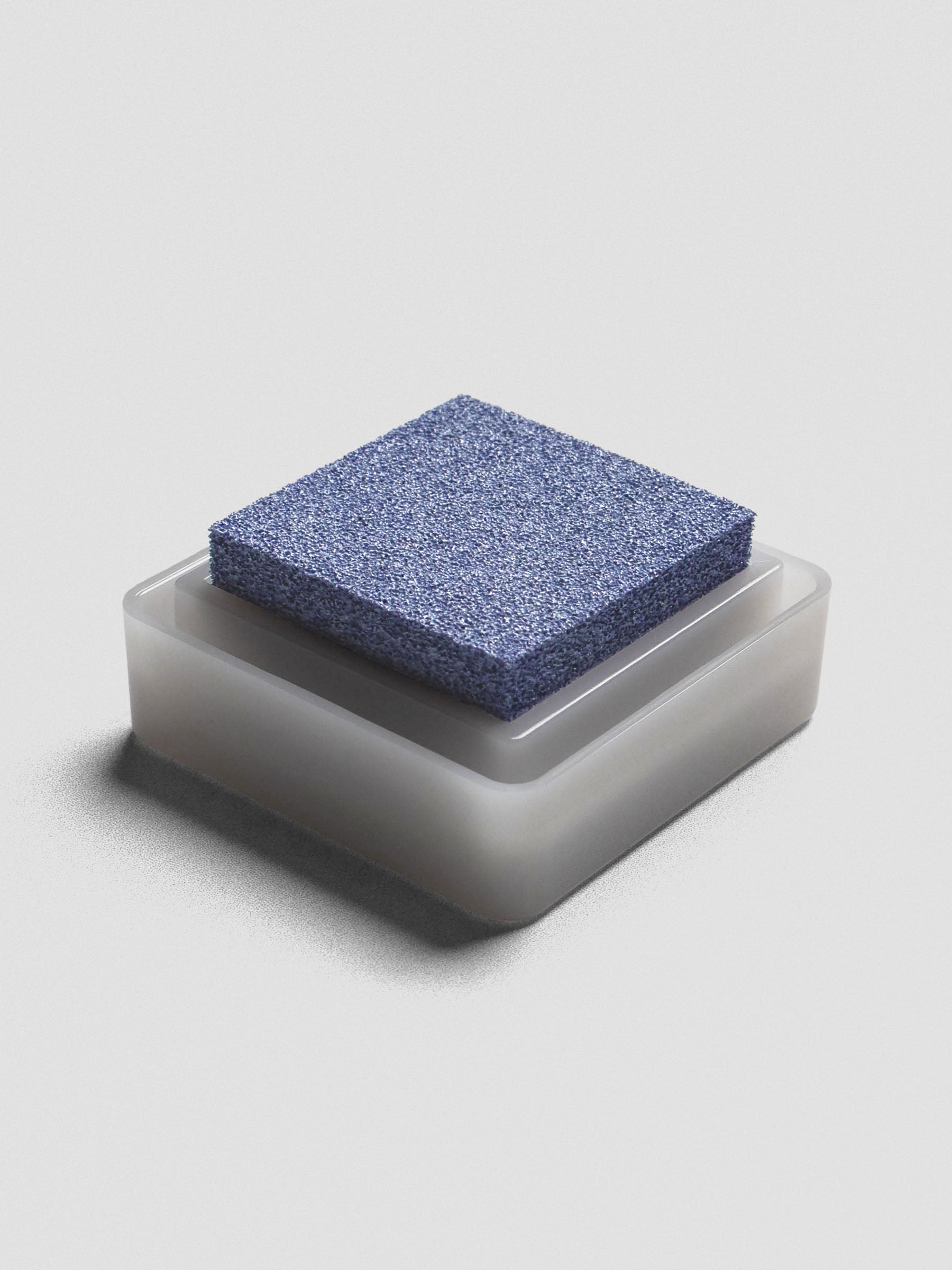 Light blue Artnic ink pad without lid, angled view of textured ink surface and white base.