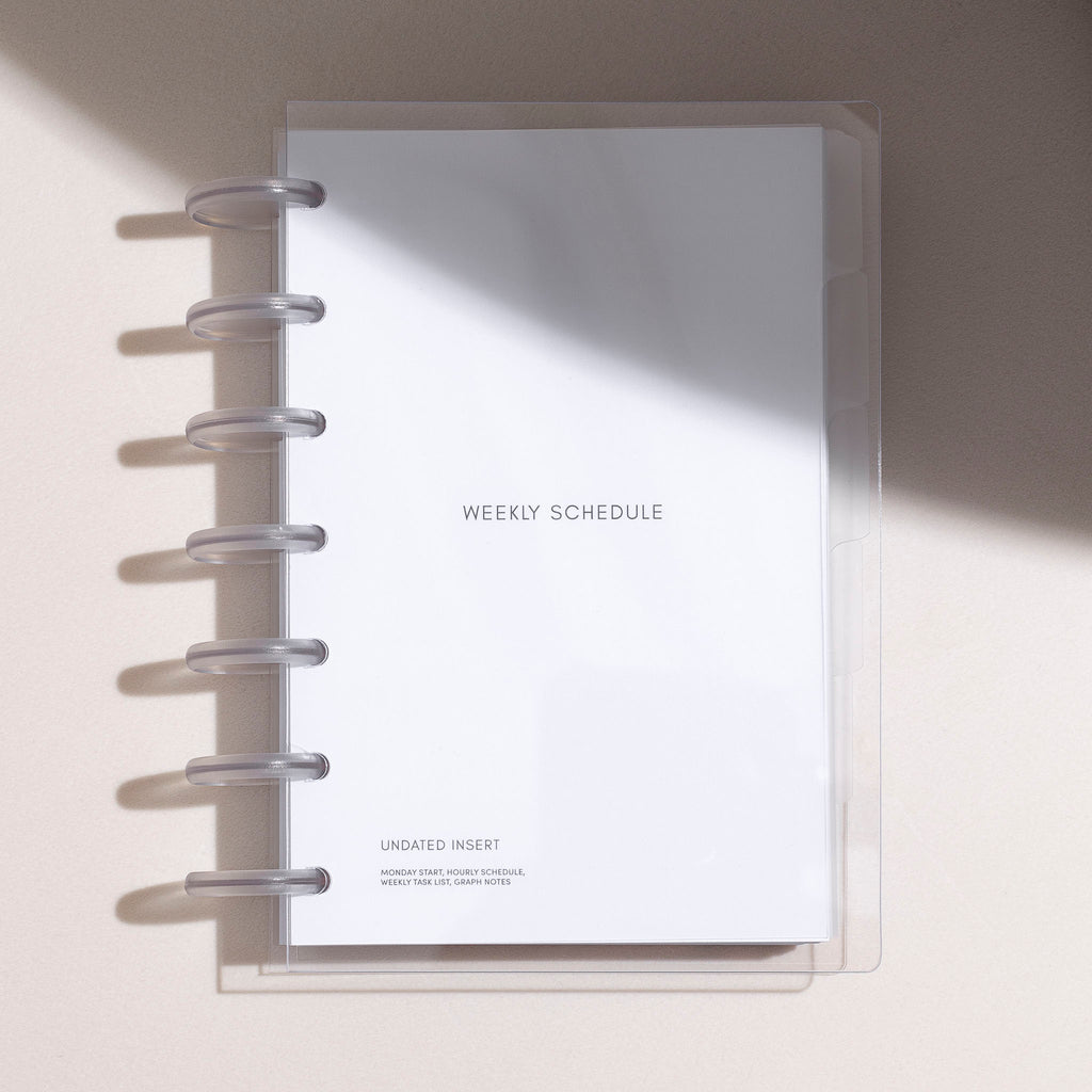 HP MINI-sized Beginner Planner Bundle enclosed in a clear vinyl cover, situated on a white table with gentle shadows. 