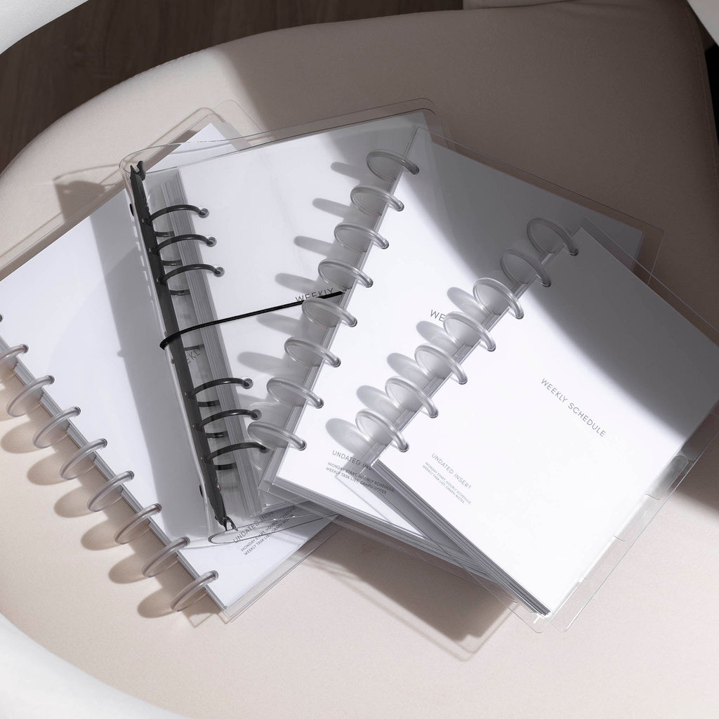 An organized stack of planner bundles, featuring various sizes such as Half Letter, HP Classic, HP Mini, and A5, beautifully arranged on a white background with soft, subtle shadows.