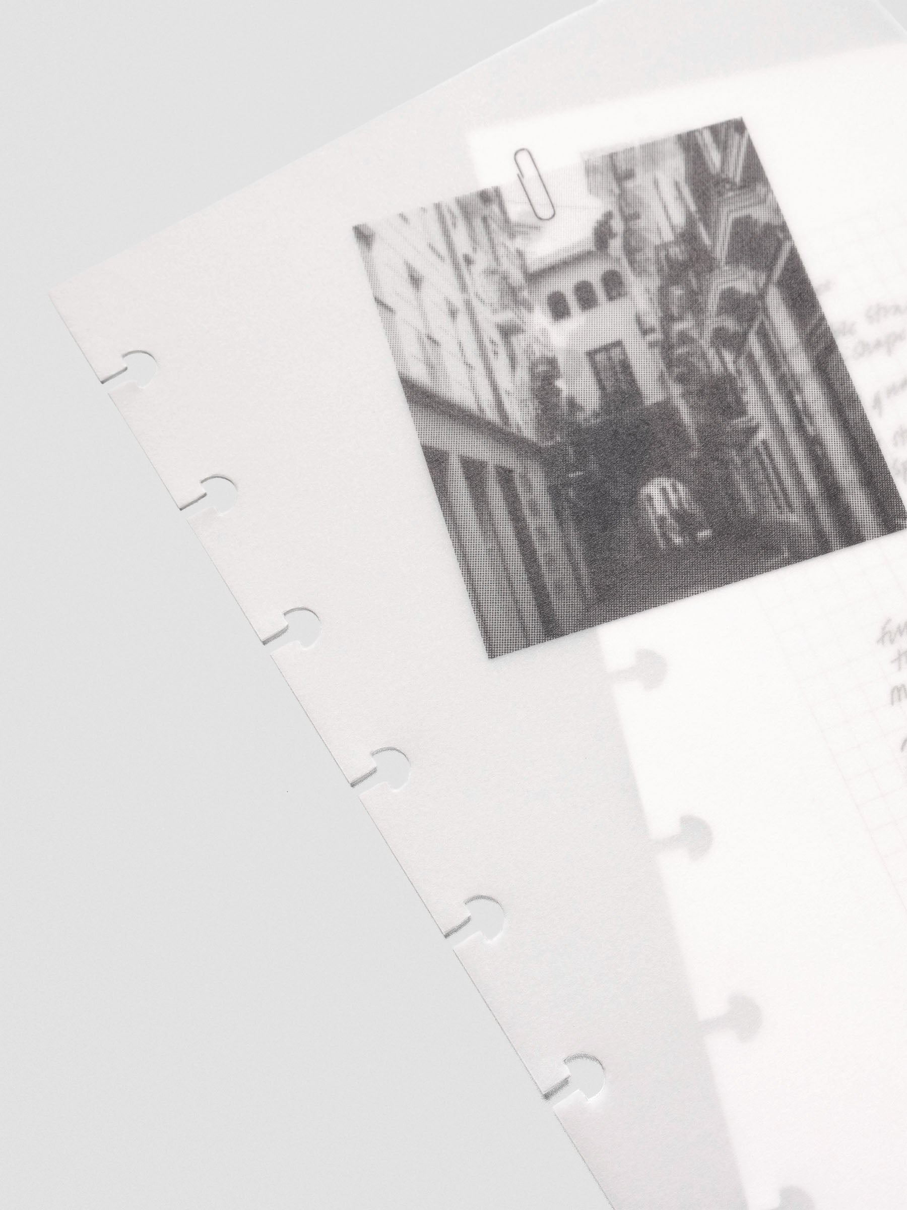 Close-up angled view of the vellum overlay from the half-letter Behind the Scenes Dashboard Duo insert, showing a black-and-white photo clipped above layered notes beneath.