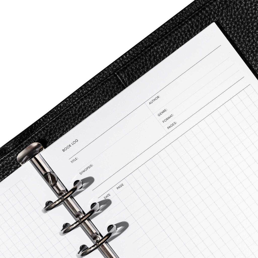 Closeup of inserts inside a black leather planner. Page displayed is the book log, with title, synopsis, author, genre, format, pages, and note fields visible.