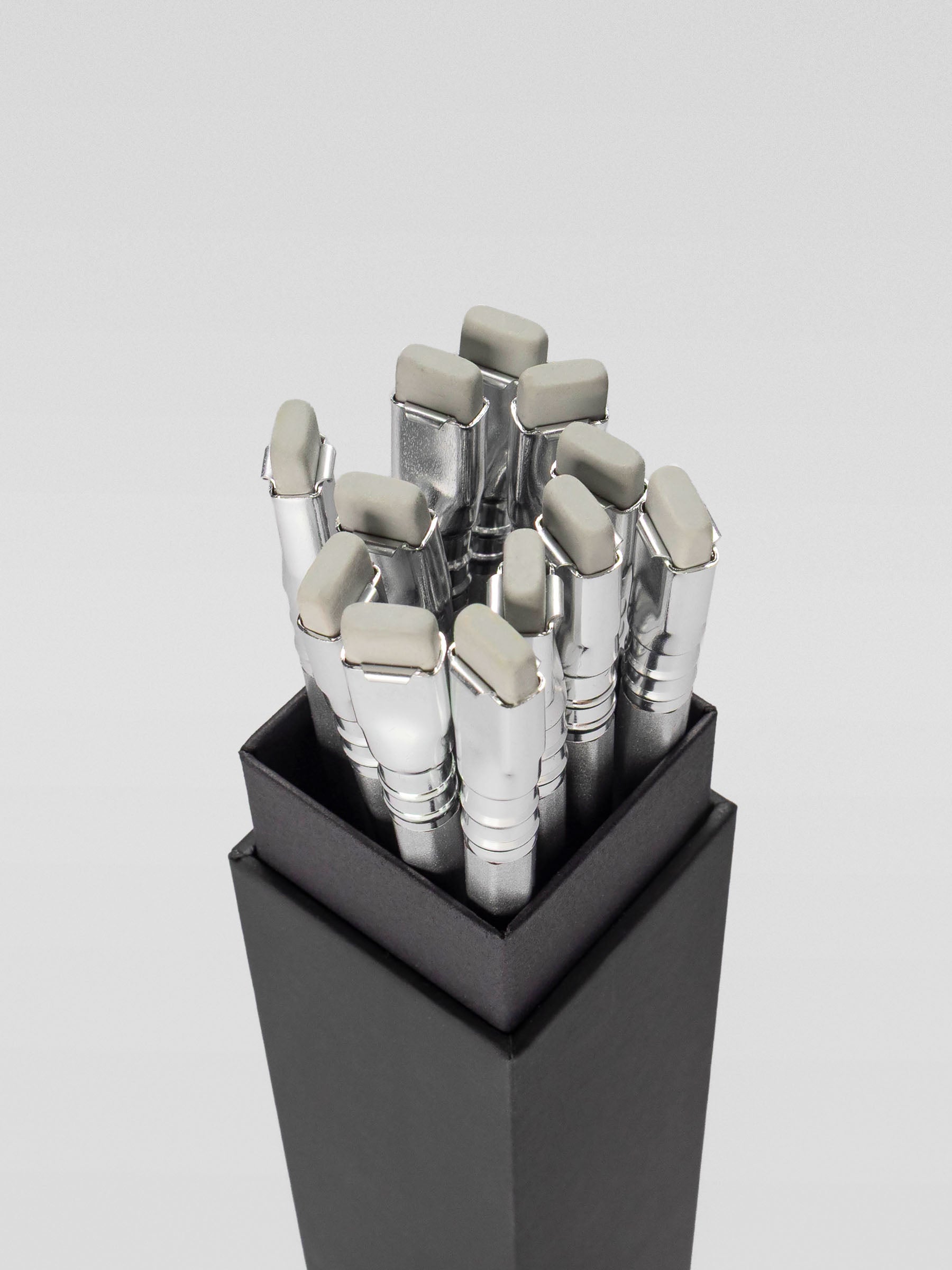 Top view of a box of Blackwing 140 pencils, showcasing the shiny silver ferrules and light gray rectangular erasers.
